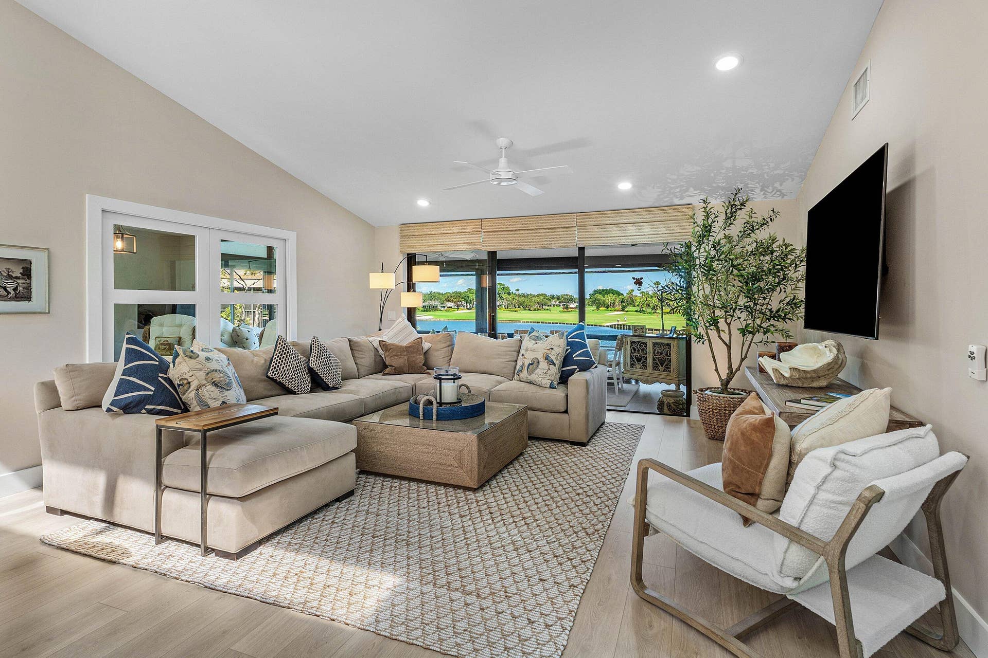 Vaulted ceilings, wood-finish flooring, recessed lighting, ceiling fan, and sliding glass doors