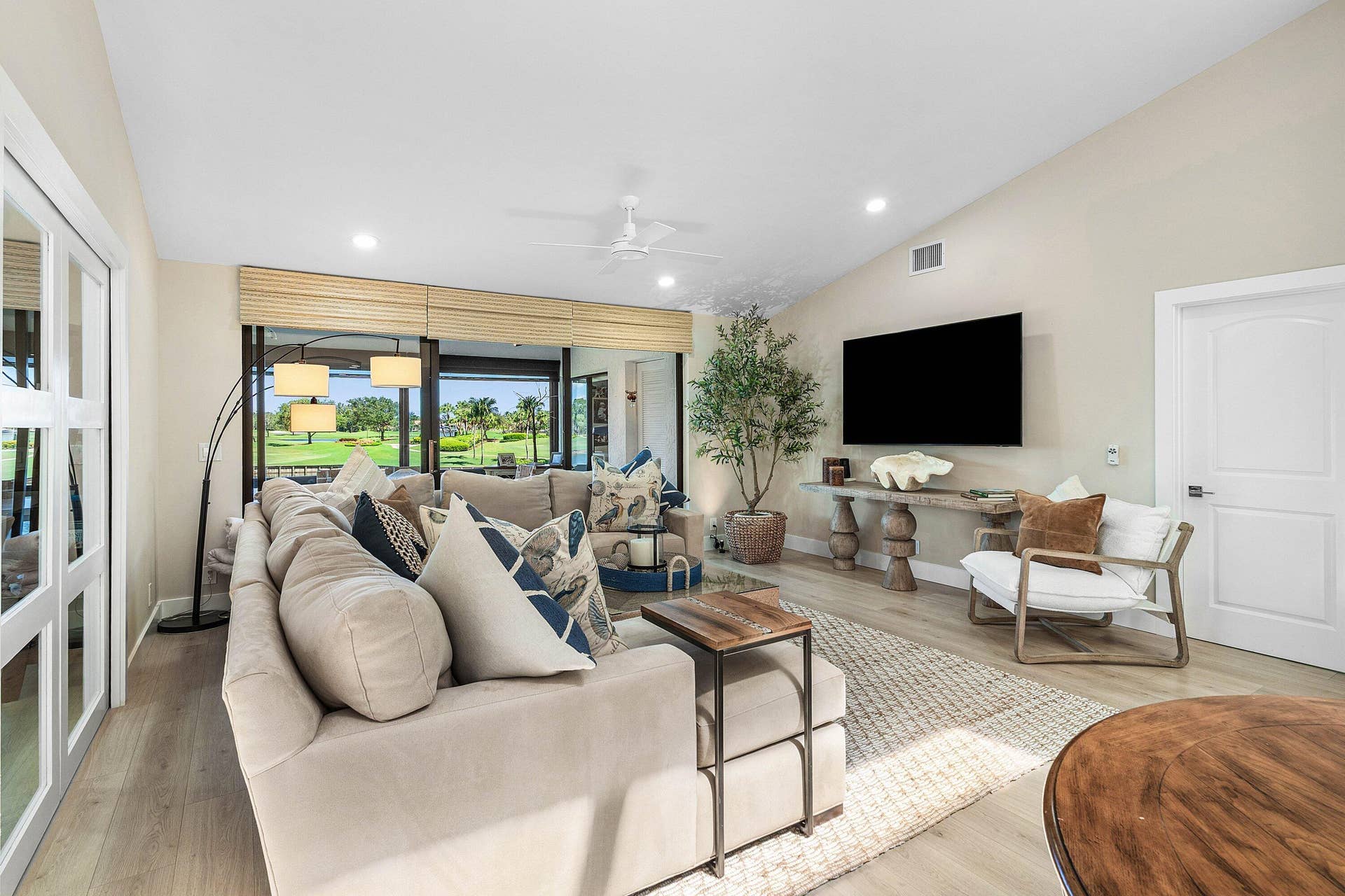Vaulted ceilings, wood-finish flooring, recessed lighting, ceiling fan, and sliding glass doors