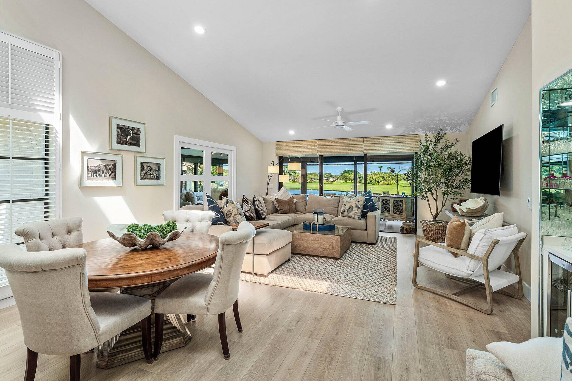 Vaulted ceilings, wood-finish flooring, recessed lighting, and expansive sliding glass doors