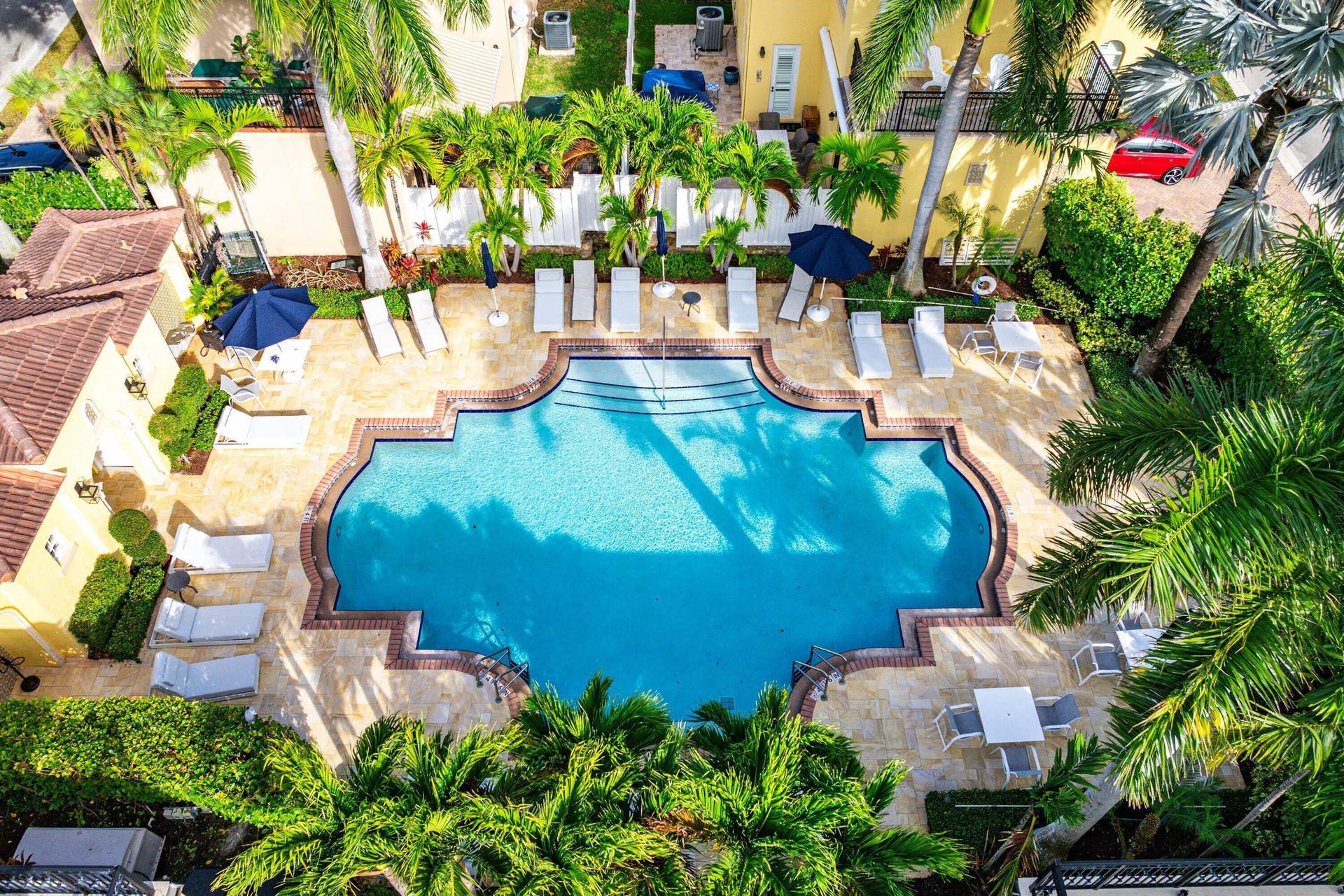 115 VIA POINCIANA Lane, Boca Raton, FL 33487 Beautiful community pool with tropical landscaping and lounge area.