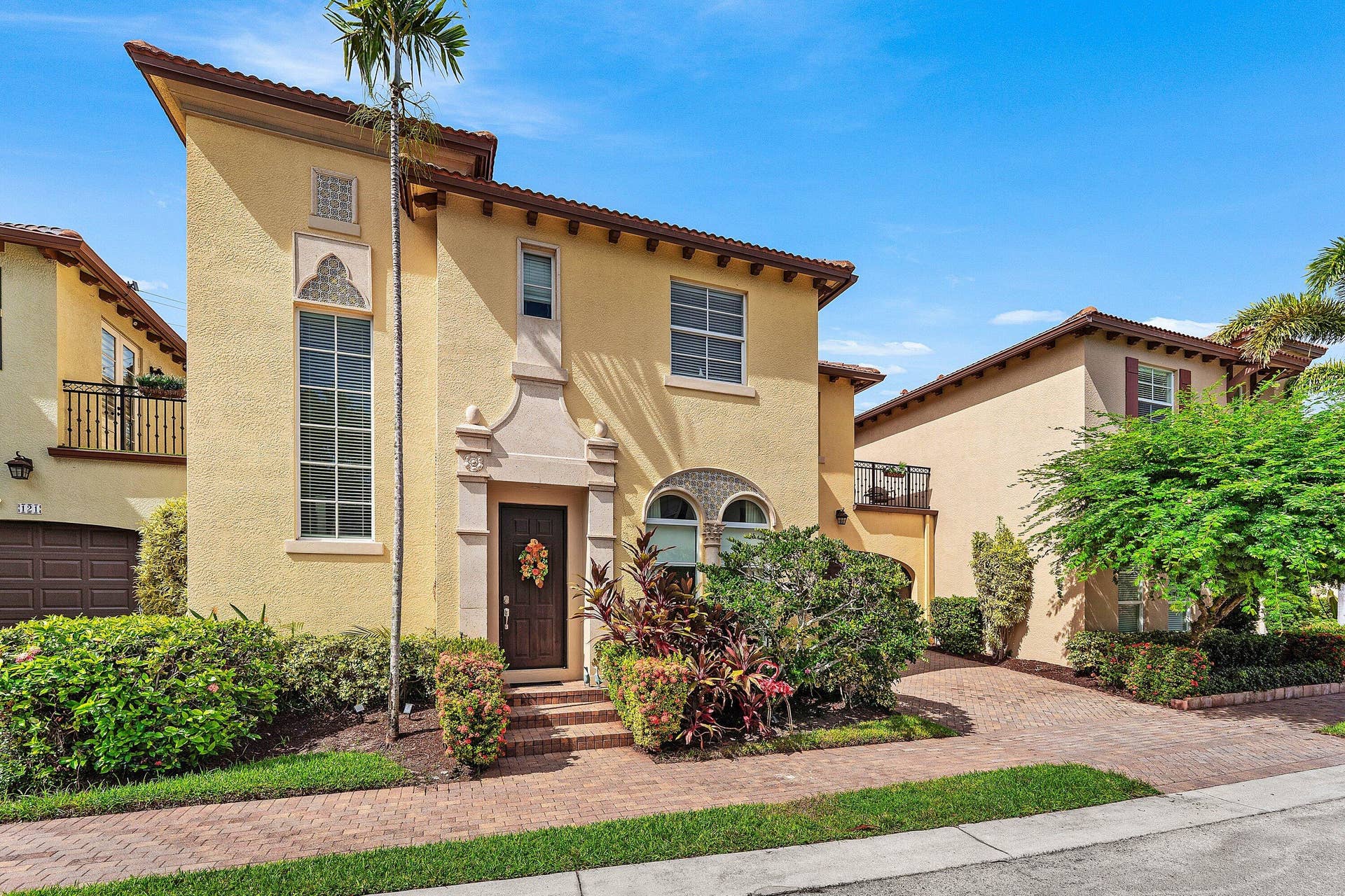 115 VIA POINCIANA Lane, Boca Raton, FL 33487 Side-angle view showcasing the homes distinctive architectural details, mature landscaping, and charming curb appeal