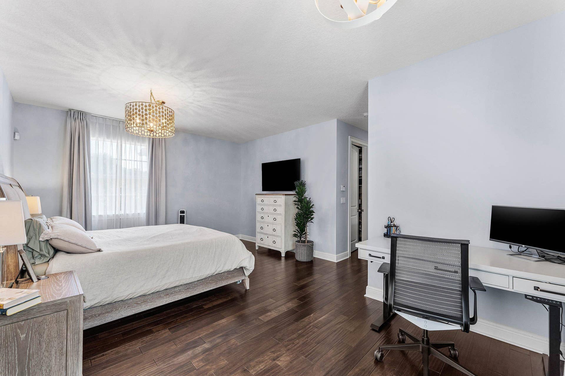 115 VIA POINCIANA Lane, Boca Raton, FL 33487 Bright master bedroom featuring wood flooring, modern furnishings, generous space, and large windows with beautiful natural light.