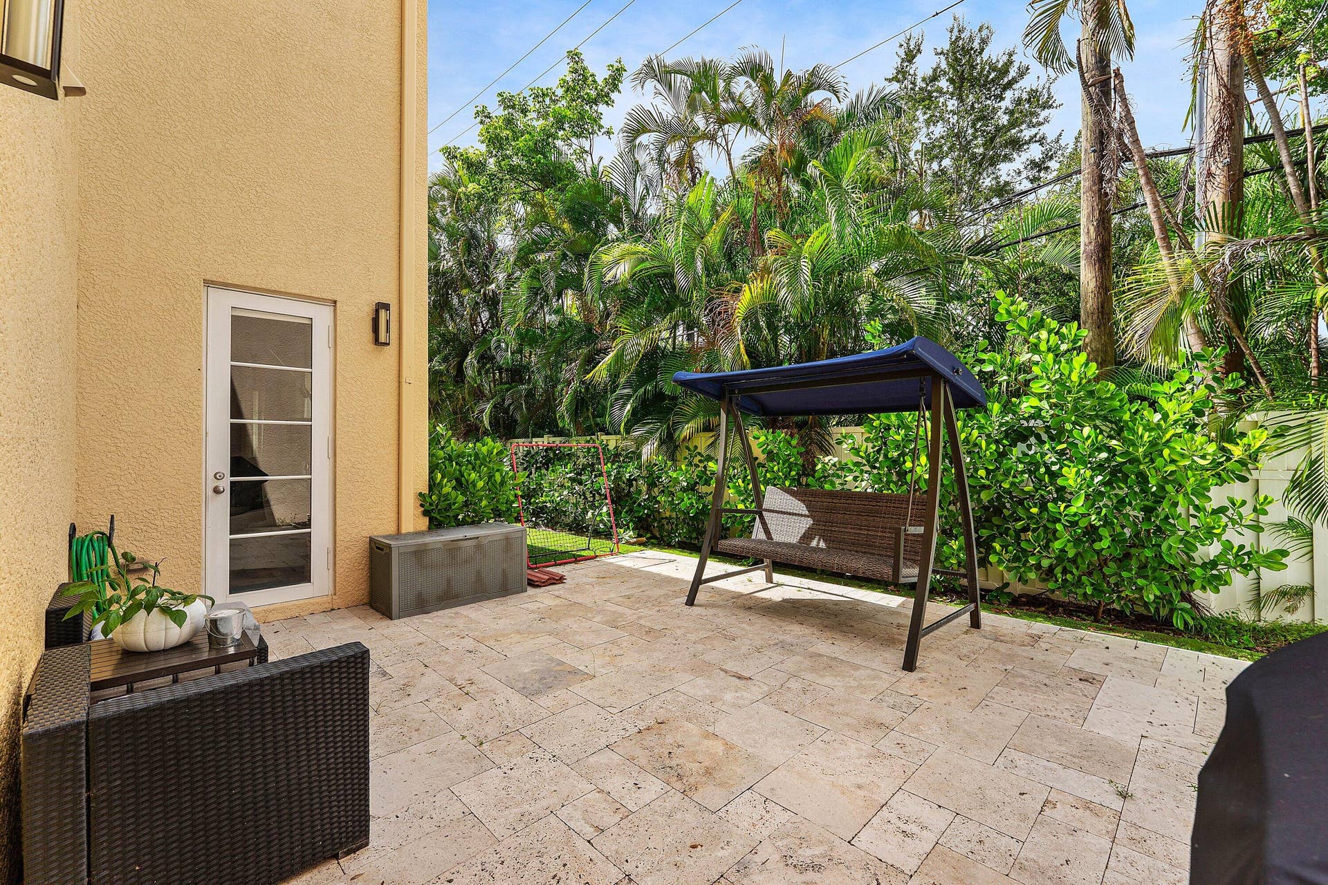 115 VIA POINCIANA Lane, Boca Raton, FL 33487 Private outdoor patio with tropical views and seating area.