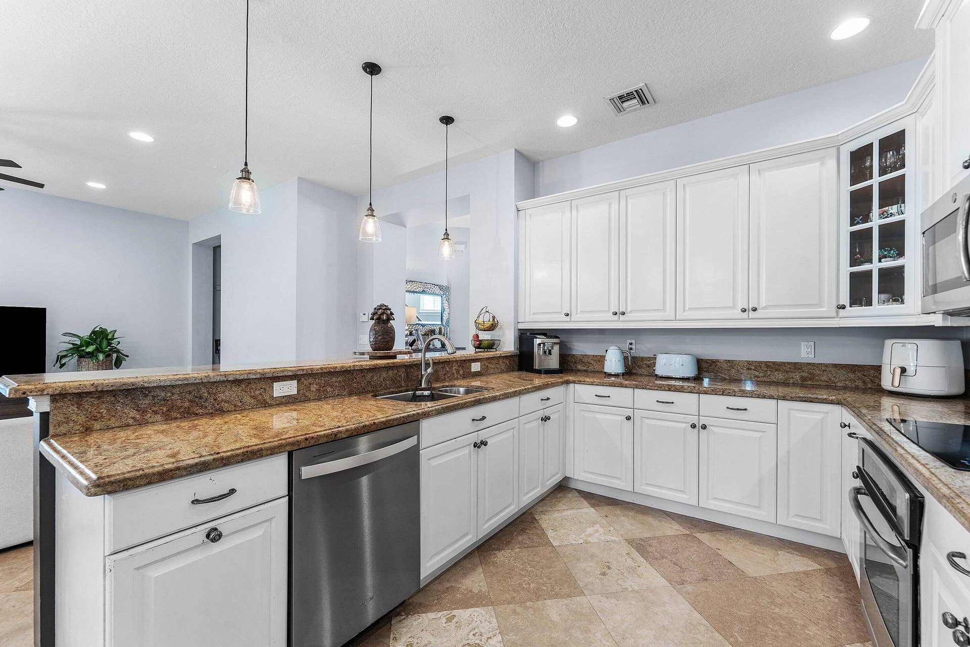 115 VIA POINCIANA Lane, Boca Raton, FL 33487 Beautiful modern kitchen showcasing white cabinets, granite countertops, stainless steel appliances, custom glass-front cabinetry, and ample counter space.