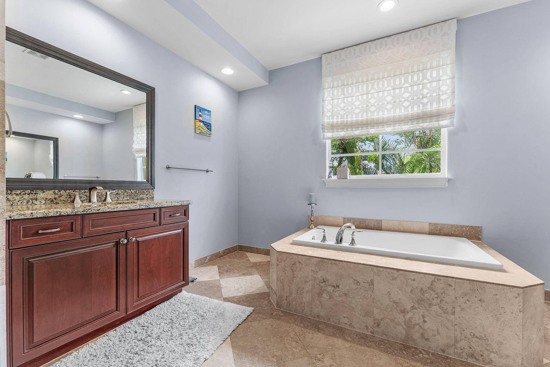 115 VIA POINCIANA Lane, Boca Raton, FL 33487 Luxurious master bathroom with a large soaking tub, dual vanities, granite countertops, and a bright, spa-like atmosphere.