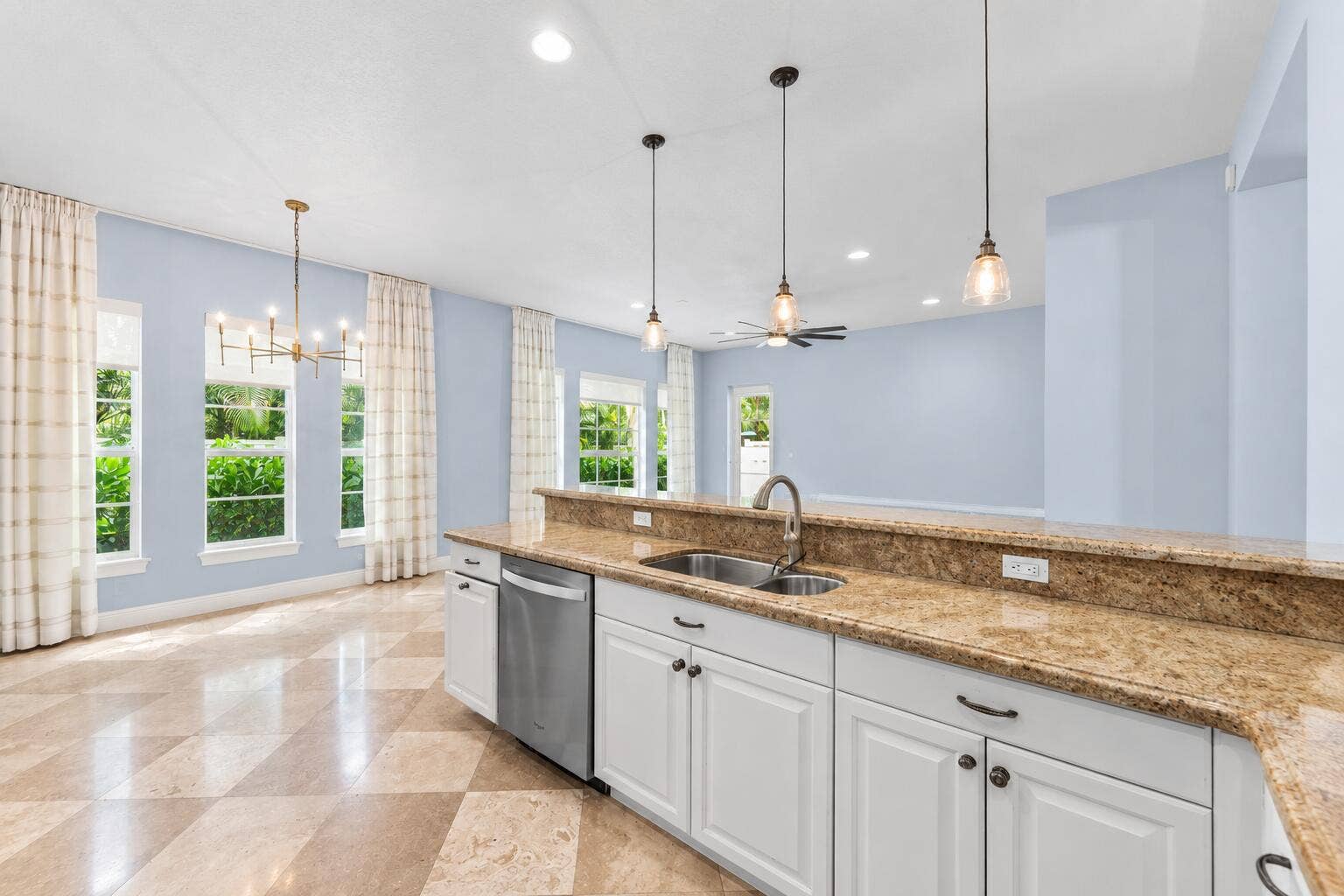 115 VIA POINCIANA Lane, Boca Raton, FL 33487 Bright open-concept kitchen with oversized island, granite countertops, white cabinetry, stainless steel appliances, and seamless flow into the living area.