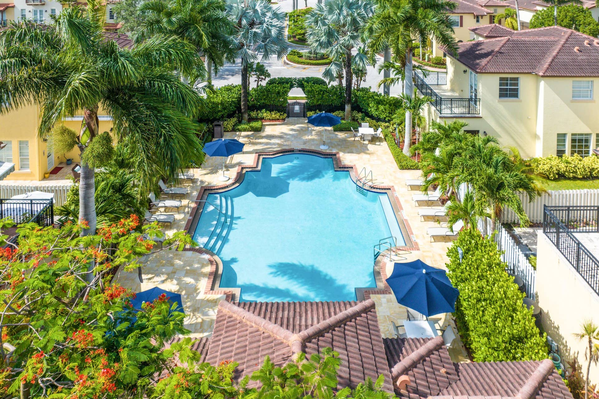 115 VIA POINCIANA Lane, Boca Raton, FL 33487 Sparkling community pool with spacious sun deck and lush greenery.