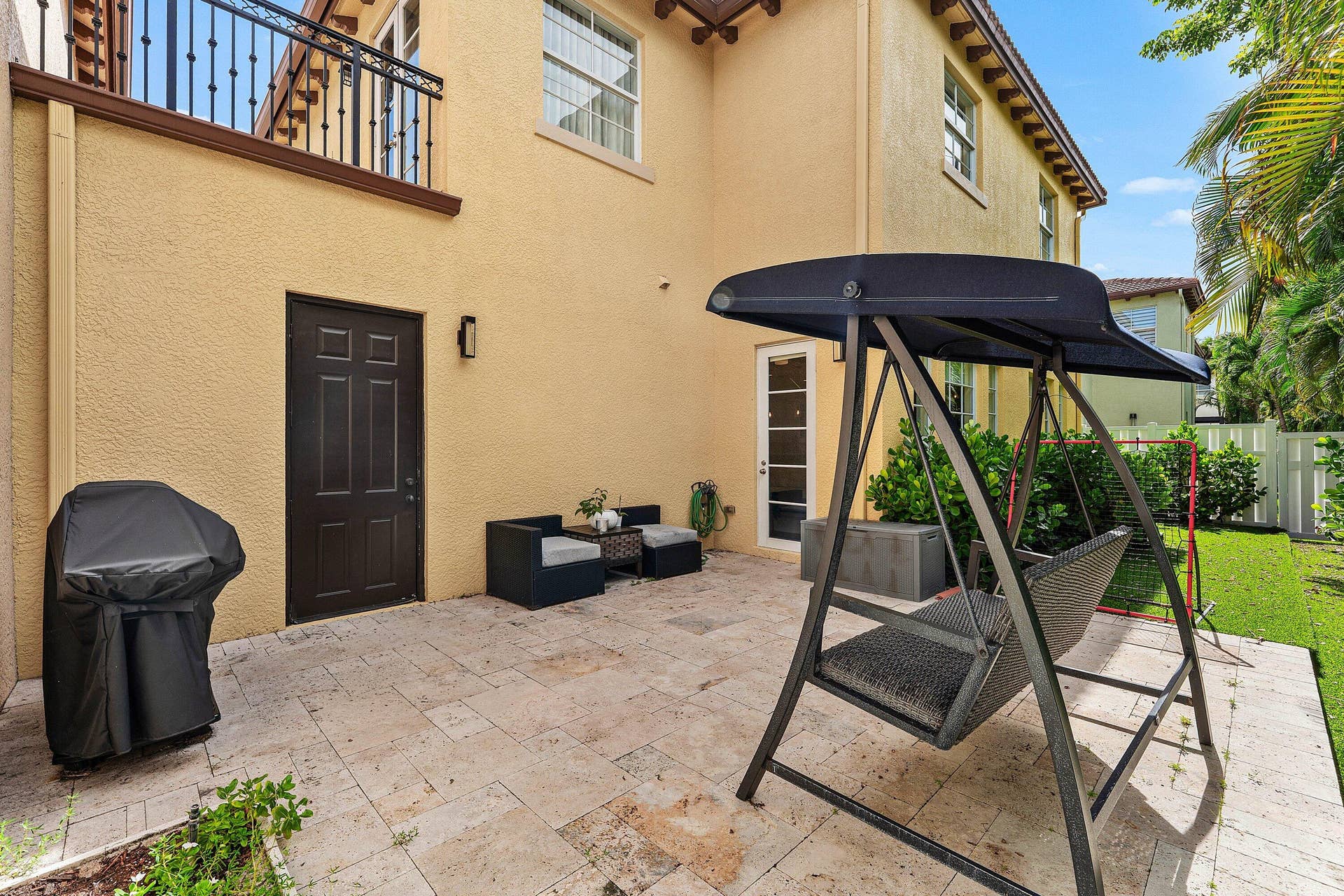 115 VIA POINCIANA Lane, Boca Raton, FL 33487 Private outdoor patio with tropical views and seating area.