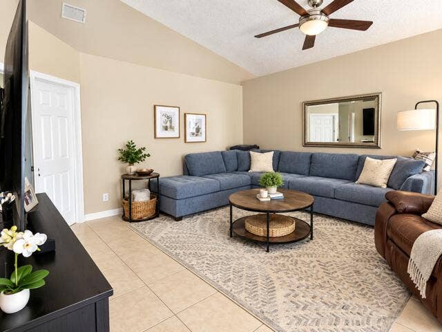 12142 Colony Preserve Drive, Boynton Beach, FL 33436 Welcoming living room offering vaulted ceilings, continuous ceramic tile flooring, ceiling fan, and an open layout ideal for entertaining.