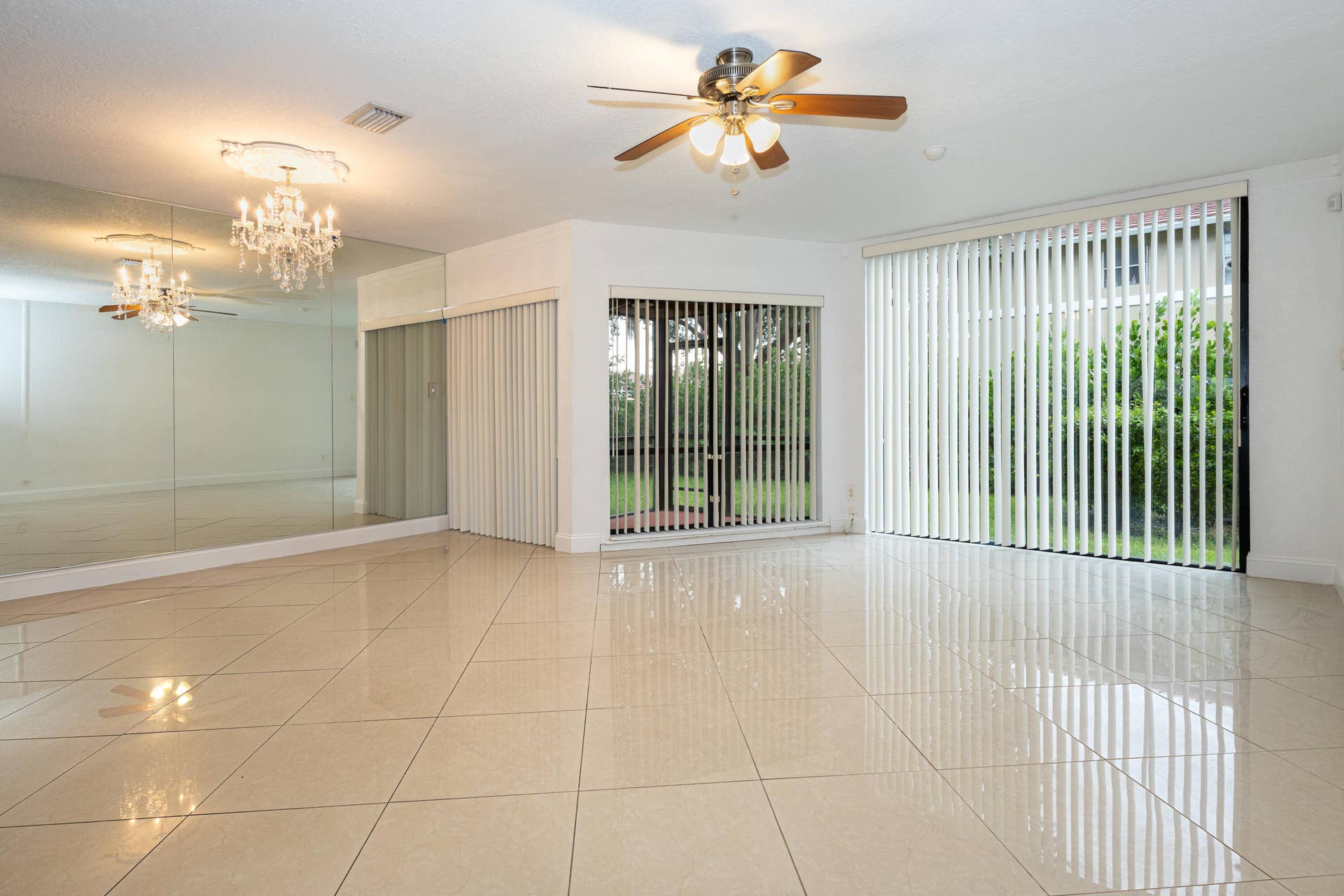 9981 W ATLANTIC Boulevard, #9981, Coral Springs, FL 33071 Spacious open-concept room showcasing polished tile flooring, recessed ceiling lighting, and a ceiling fan with brushed metal finish