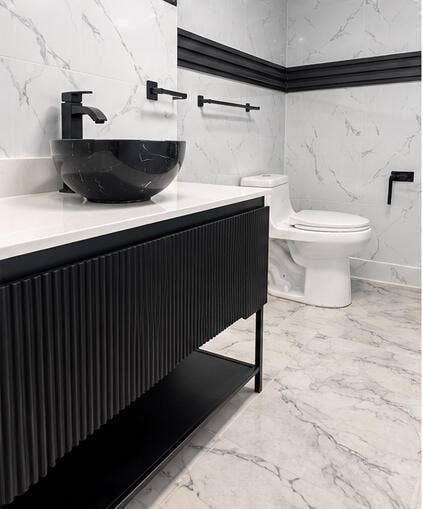 3601 SW 54th Avenue, West Park, FL 33023 Black fluted vanity with a white countertop and a circular vessel sink, complemented by matte black hardware, wall-mounted faucet, and floor-to-ceiling stone-patterned wall tiling