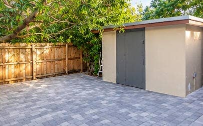 3601 SW 54th Avenue, West Park, FL 33023 Paver patio area with a detached storage structure and wood-panel fencing