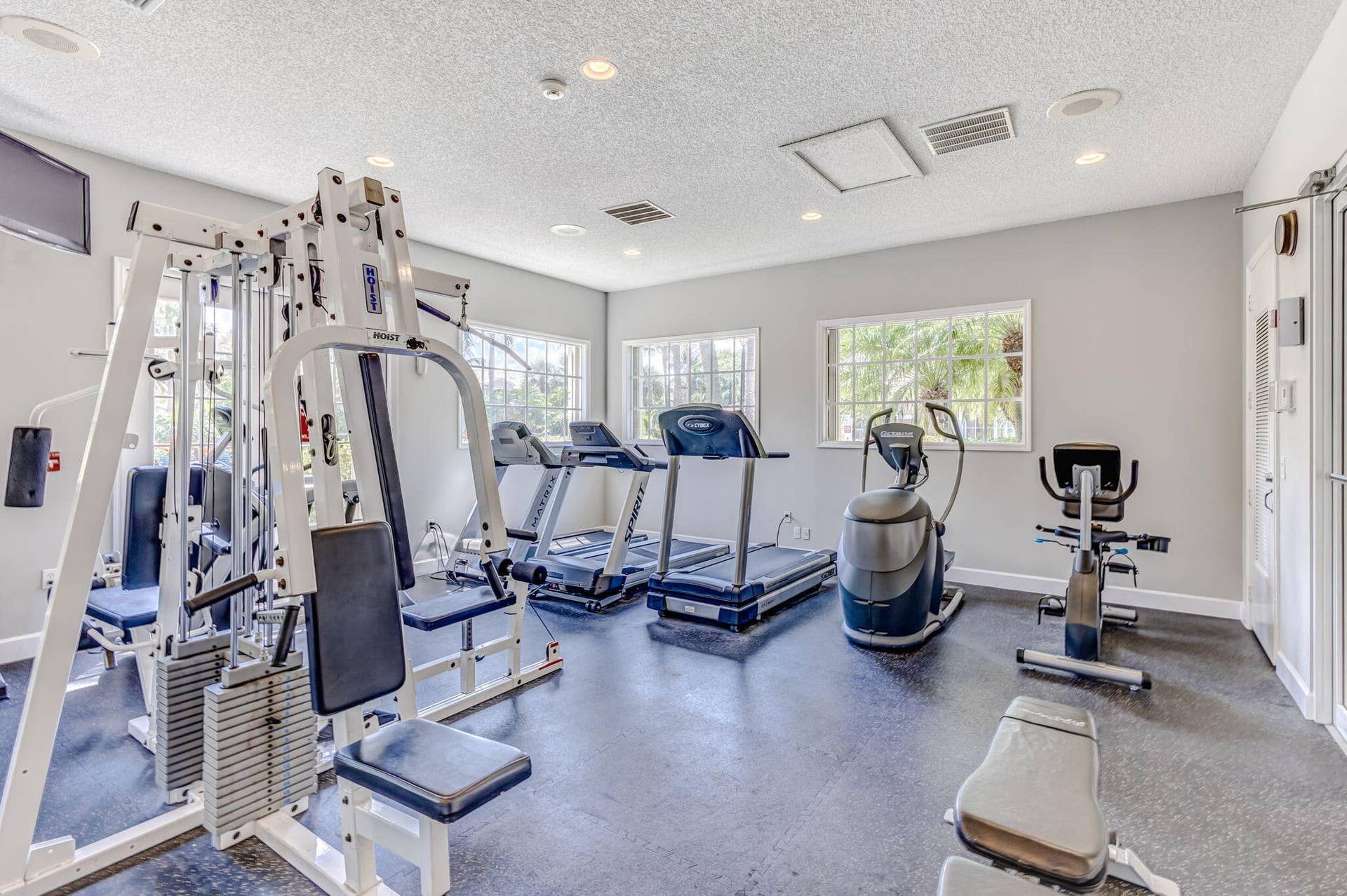 Fitness center featuring rubber flooring, recessed lighting, and multiple windows