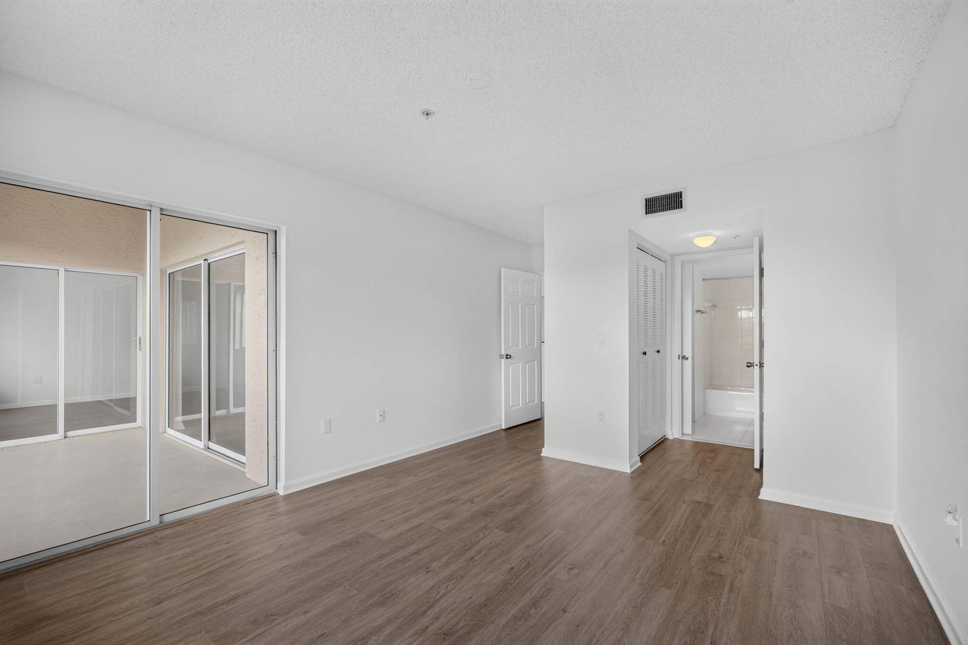 Vinyl Plank flooring, sliding glass patio door, and bi-fold closet doors