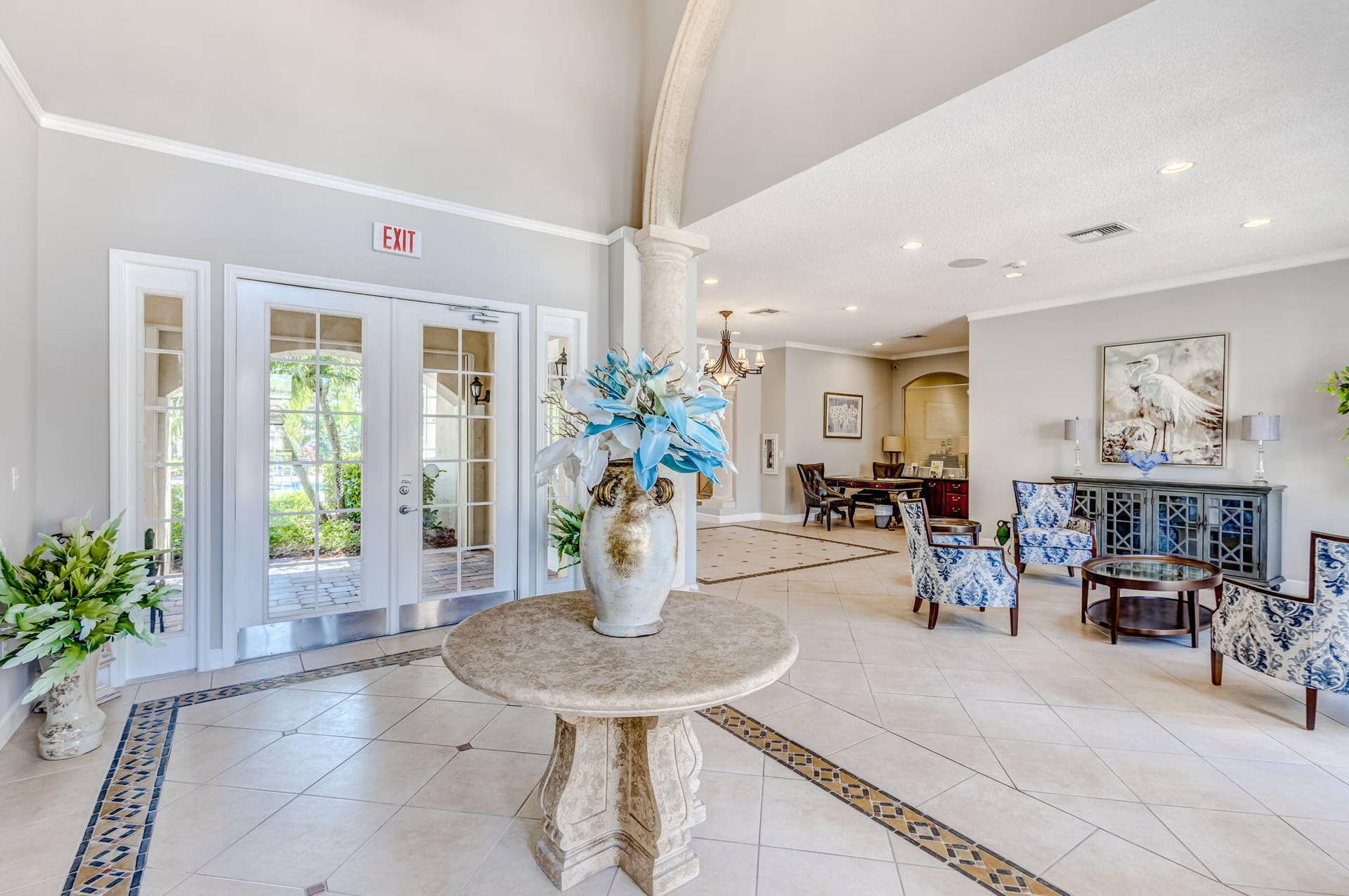 Grand entryway featuring vaulted ceilings, an arched column, recessed lighting, and tile flooring with decorative inlay borders
