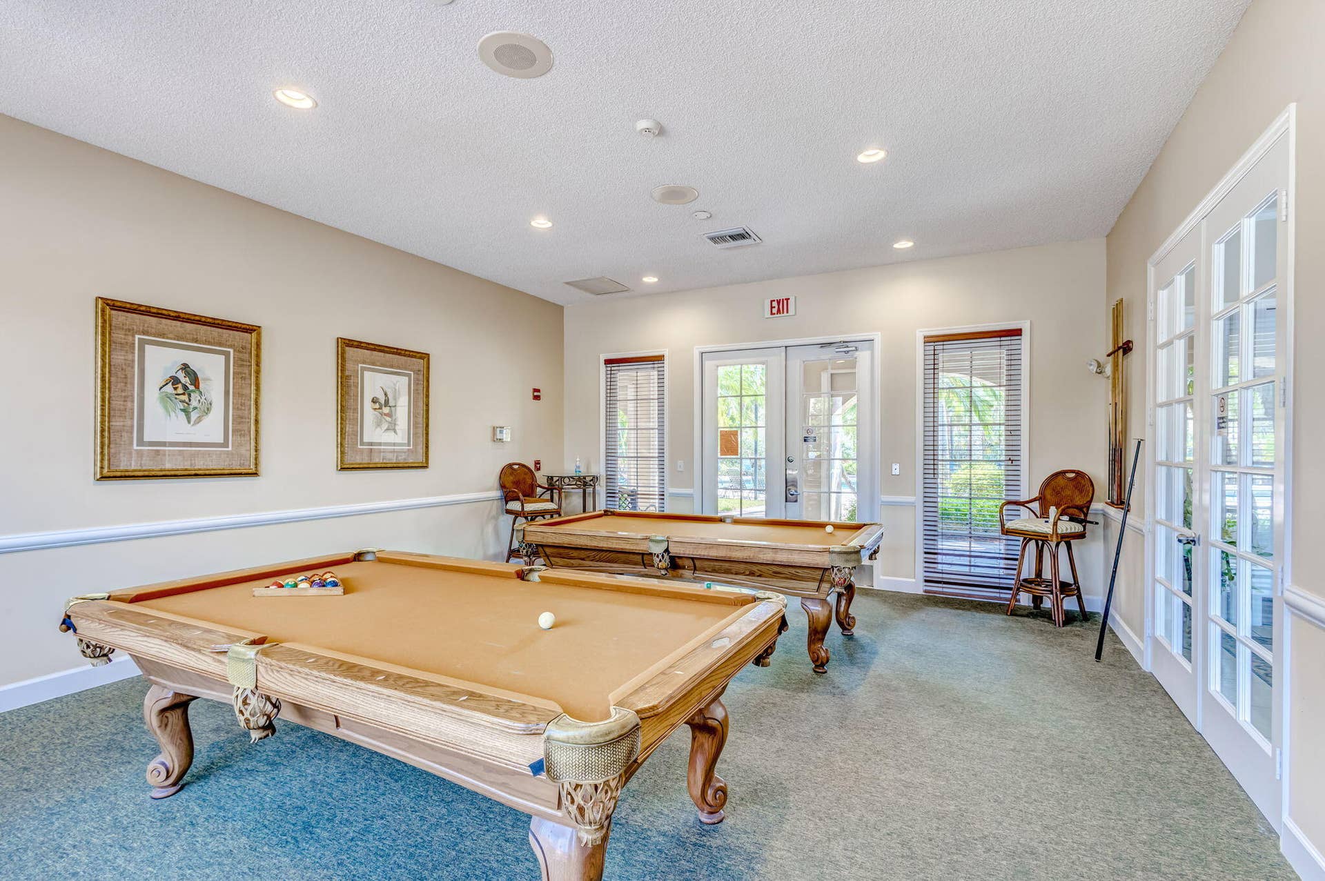 Recreation room featuring recessed lighting, chair rail molding, and multiple glass-paneled entry doors
