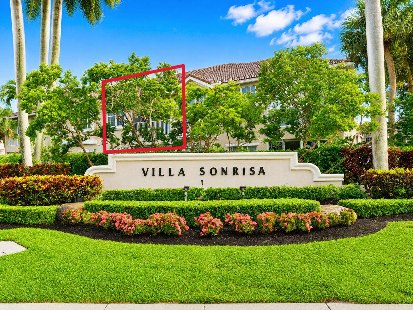 6560 VILLA SONRISA Drive, #1321, Boca Raton, FL 33433 Stucco exterior facade featuring a tile roof, screened balcony, and mature tropical landscaping
