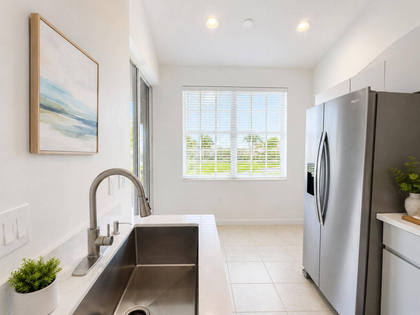 6560 VILLA SONRISA Drive, #1321, Boca Raton, FL 33433 Stainless steel refrigerator, undermount rectangular kitchen sink with a high-arc pull-down faucet, quartz countertops, tile flooring, and recessed ceiling lighting