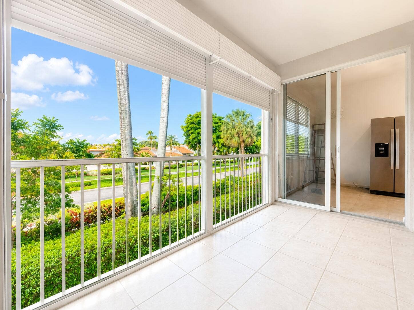 6560 VILLA SONRISA Drive, #1321, Boca Raton, FL 33433 Enclosed balcony featuring white tile flooring, aluminum railings, overhead roll-down shutters, and sliding glass entry doors