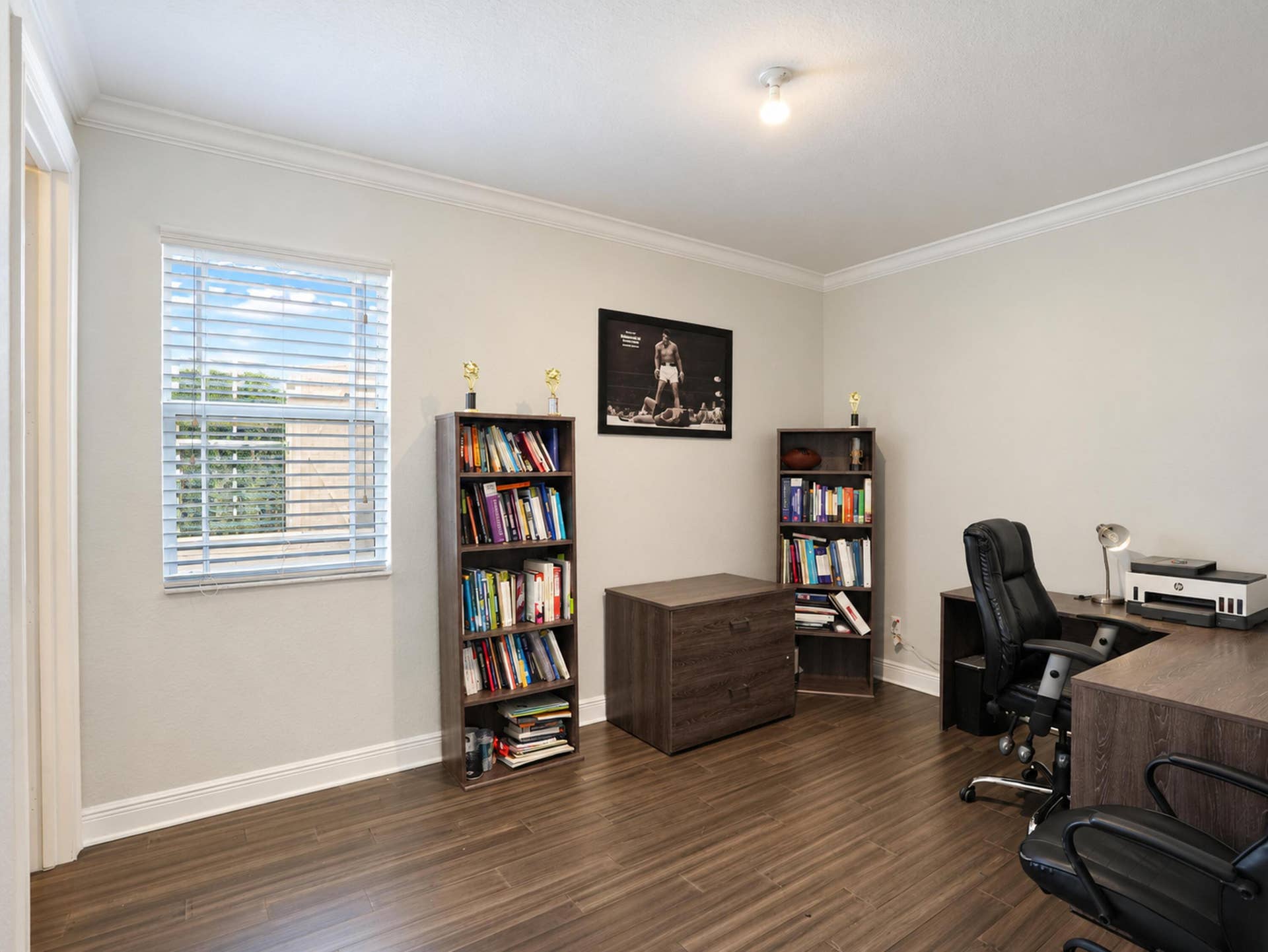 8601 Waterside Court, Parkland, FL 33076 Wood-finish flooring, neutral wall tones, crown molding, and a single-pane window with horizontal blinds