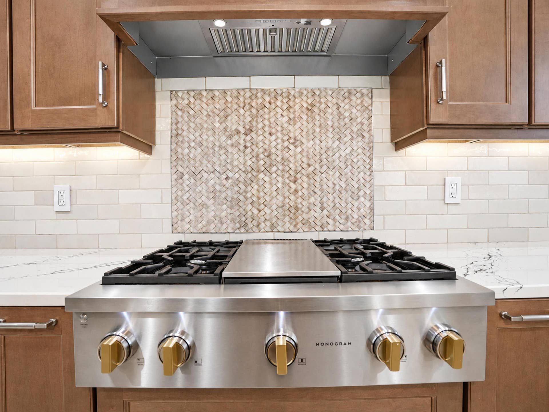 8601 Waterside Court, Parkland, FL 33076 Professional-grade stainless steel gas range with integrated griddle, custom tile backsplash with herringbone pattern insert, stone-finish countertops, and under-cabinet task lighting