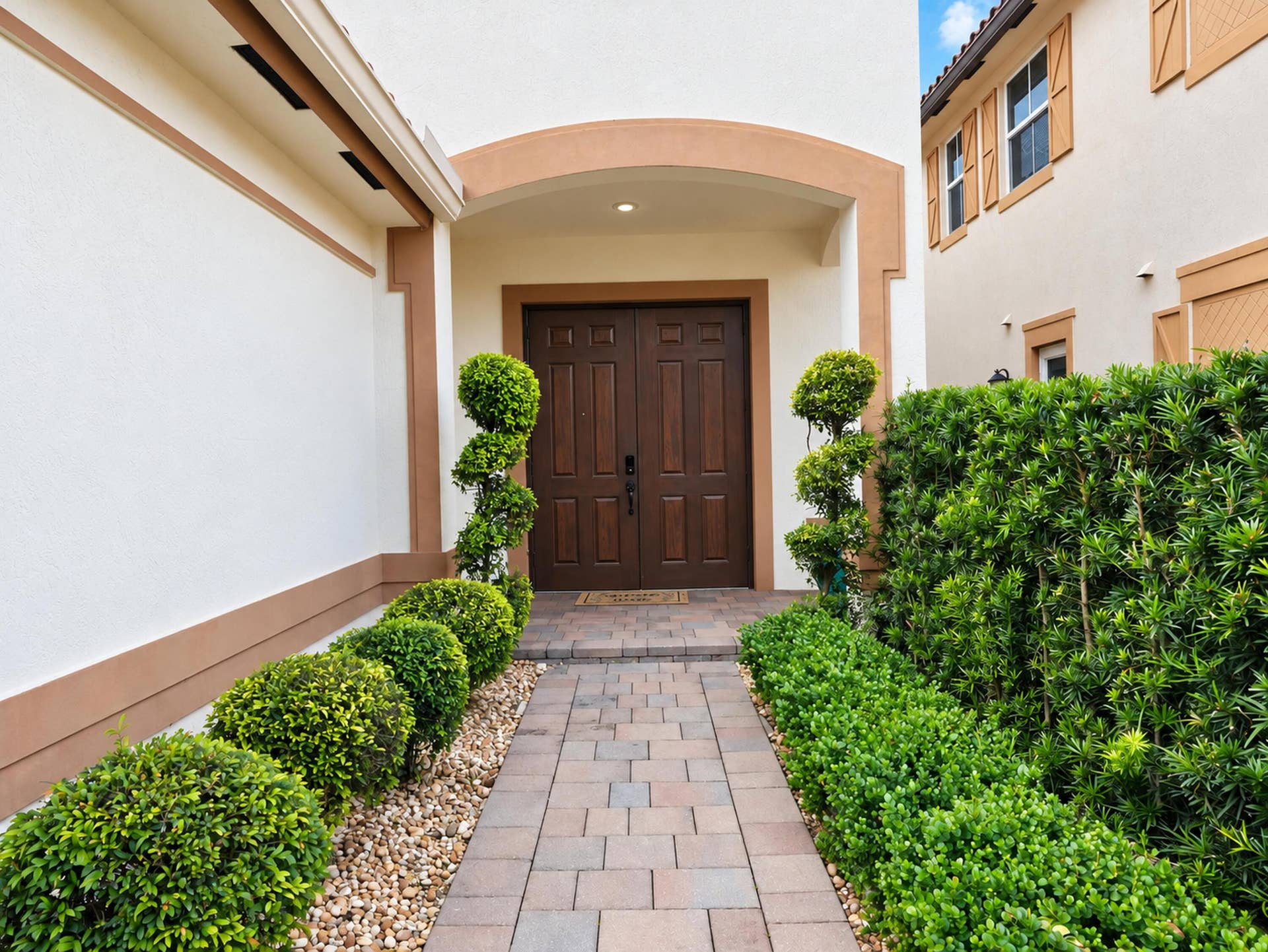 8601 Waterside Court, Parkland, FL 33076 Stucco exterior entryway featuring a double-door entry, arched portico, and paver walkway