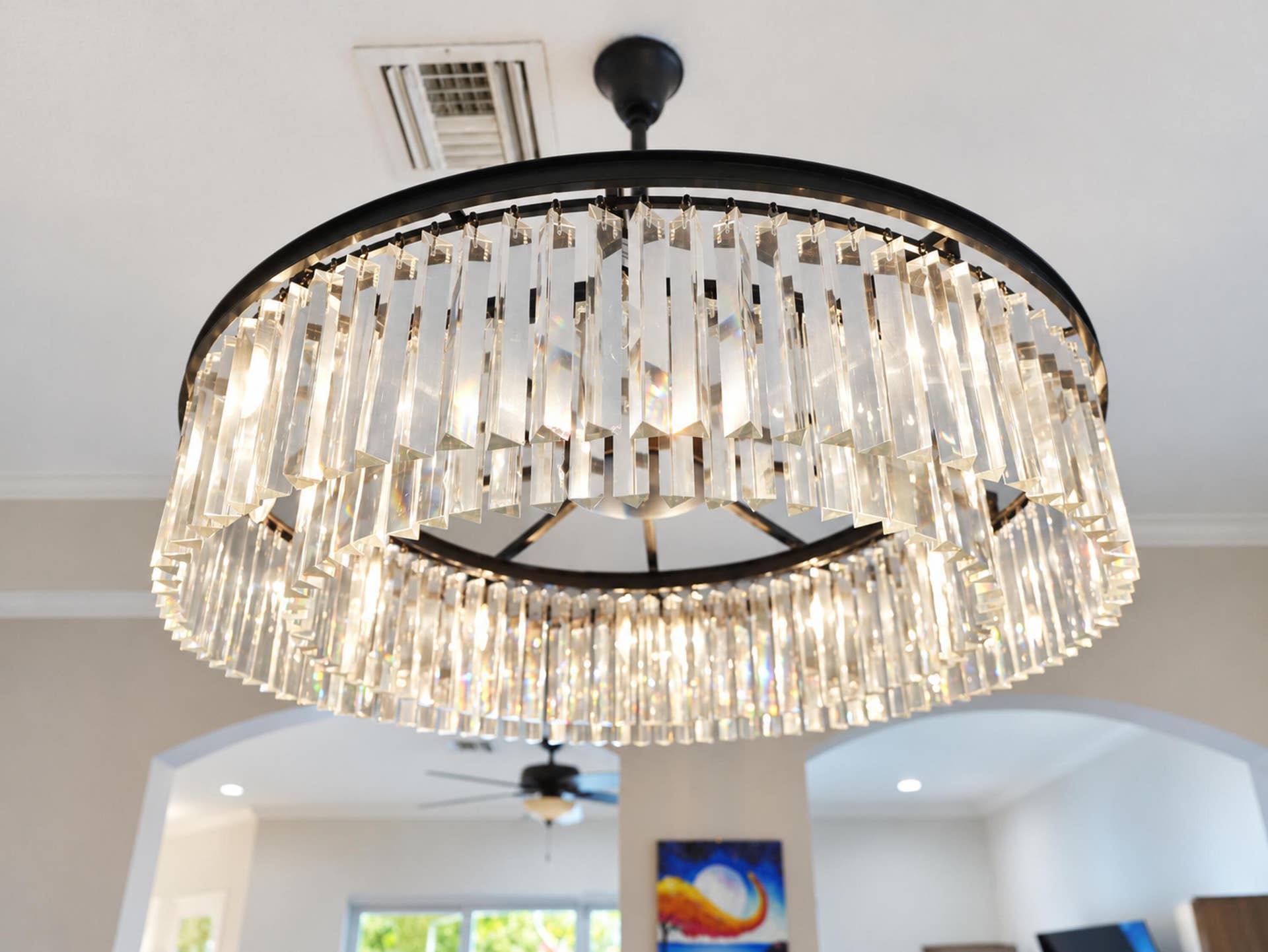 8601 Waterside Court, Parkland, FL 33076 Circular chandelier featuring tiered, vertical clear glass prisms set in a black metal frame