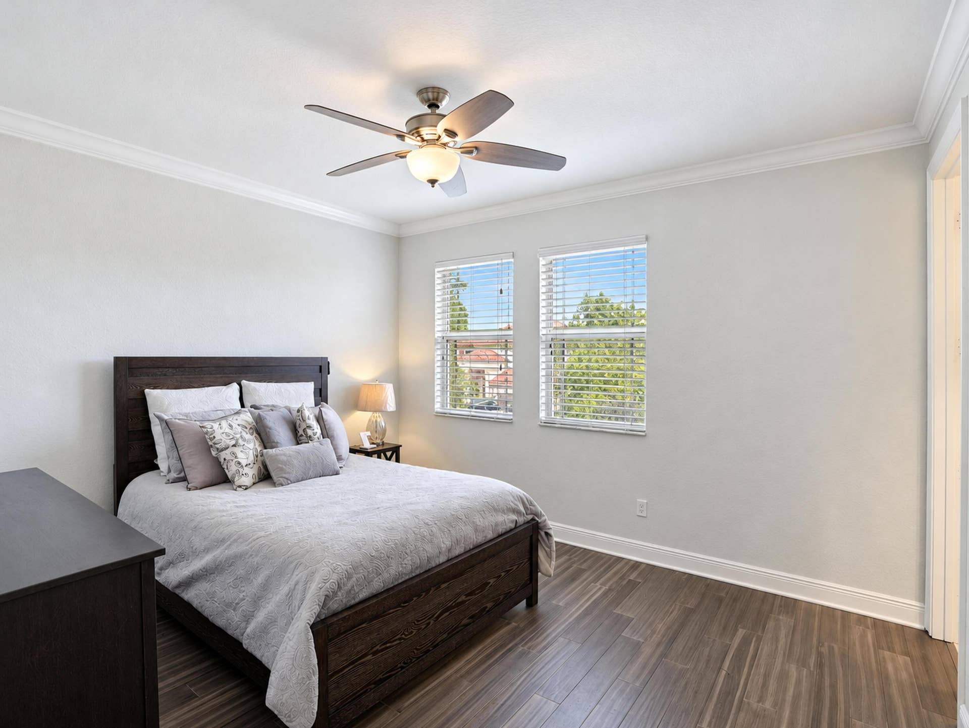 8601 Waterside Court, Parkland, FL 33076 Room featuring wood-finish flooring, crown molding, dual windows with horizontal blinds, and a centrally mounted ceiling fan with integrated lighting