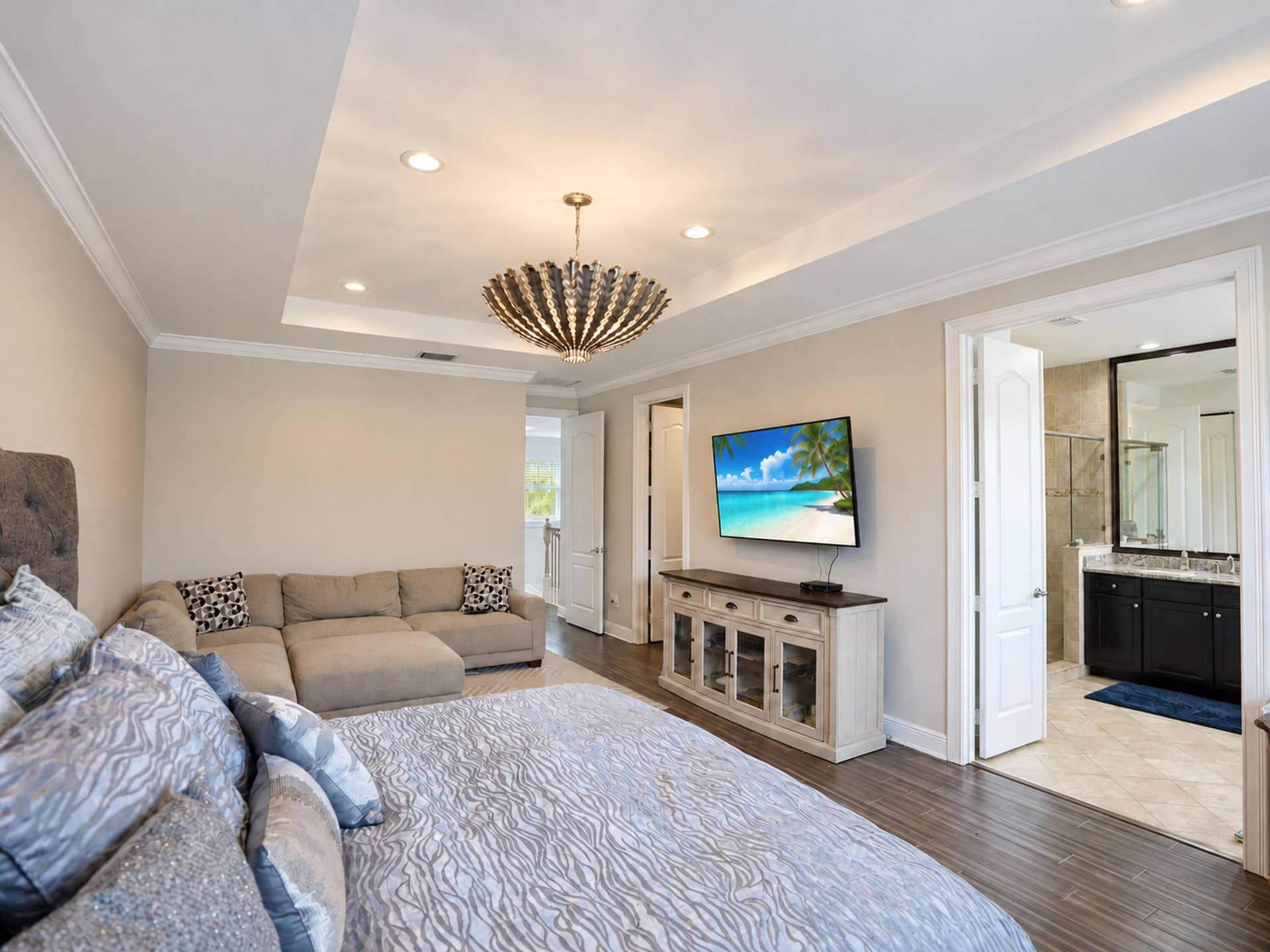 8601 Waterside Court, Parkland, FL 33076 Tray ceiling with recessed lighting, statement chandelier (excluded), wood-finish flooring, and crown molding