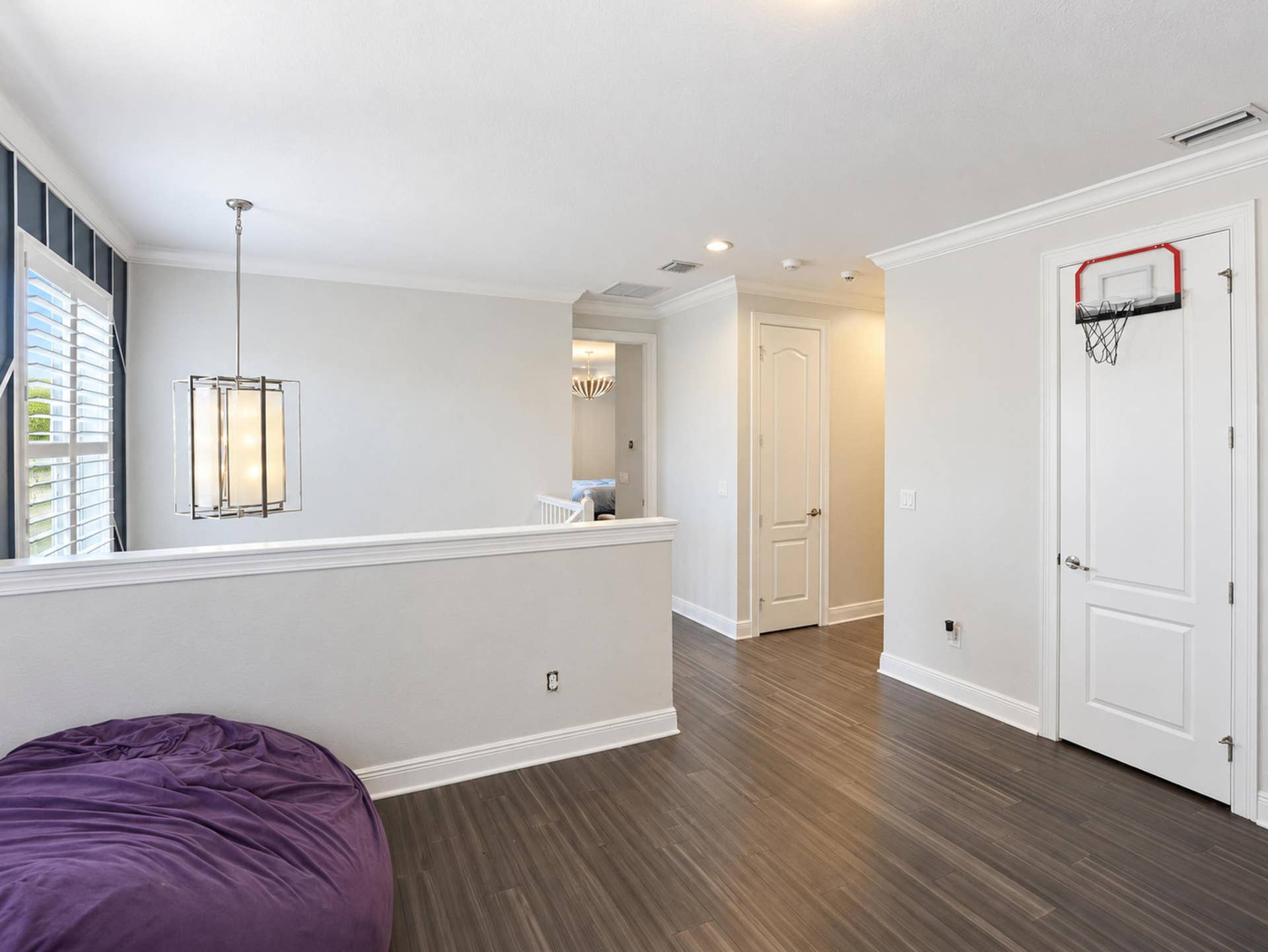 8601 Waterside Court, Parkland, FL 33076 Wood-finish flooring, crown molding, multi-panel doors, and a decorative pendant light fixture