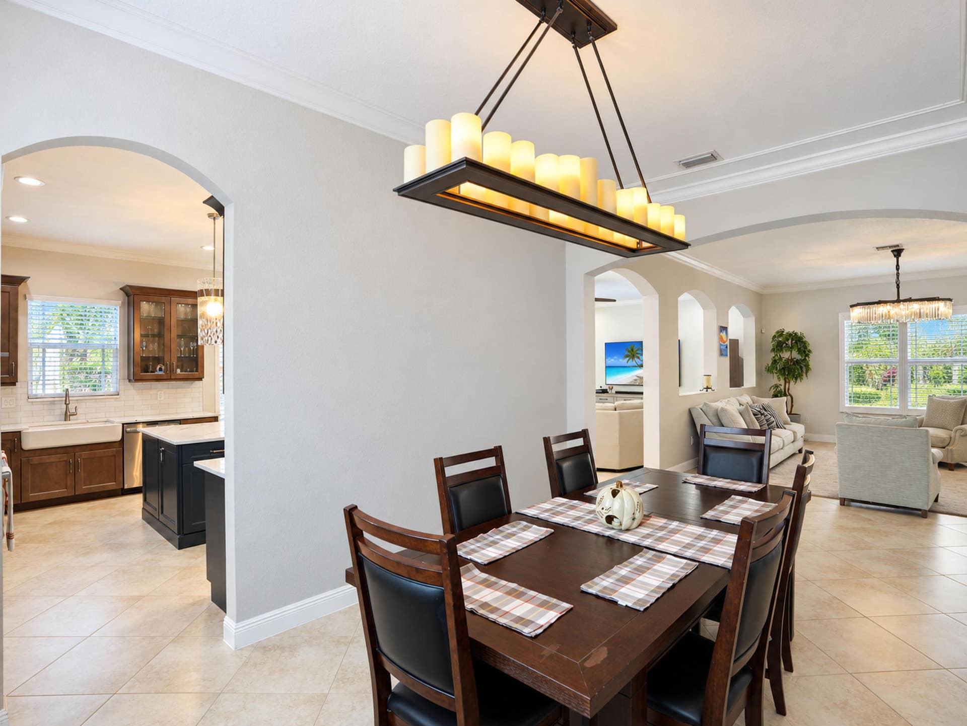 8601 Waterside Court, Parkland, FL 33076 Architectural archways, candle-style rectangular chandelier, crown molding, and large-format tile flooring