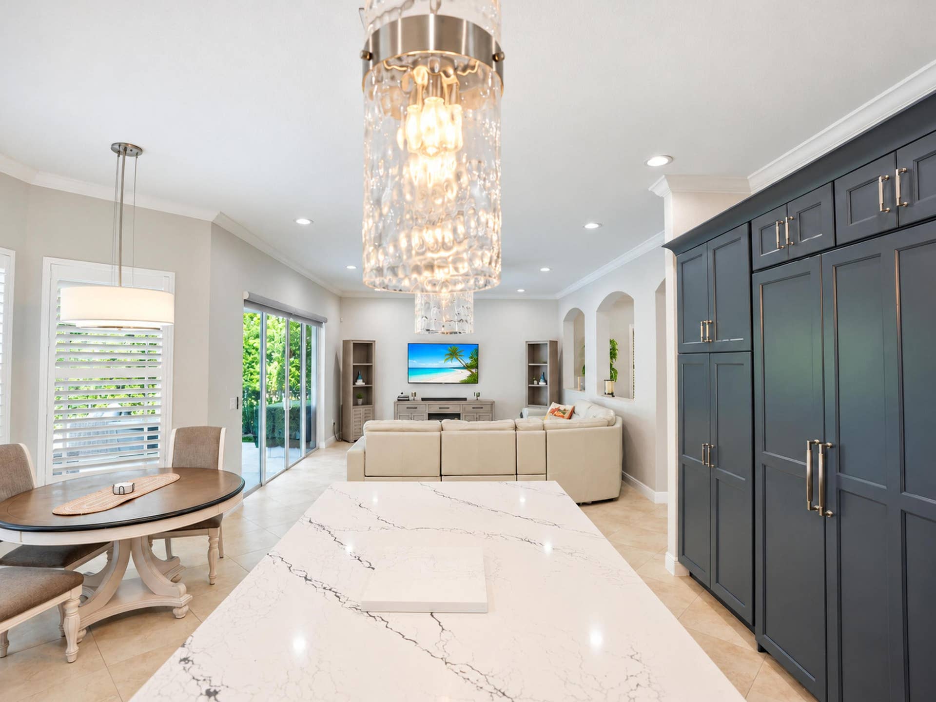 8601 Waterside Court, Parkland, FL 33076 Large kitchen island with a stone countertop, floor-to-ceiling dark cabinetry, crystal statement lighting, recessed ceiling lights, and tile flooring