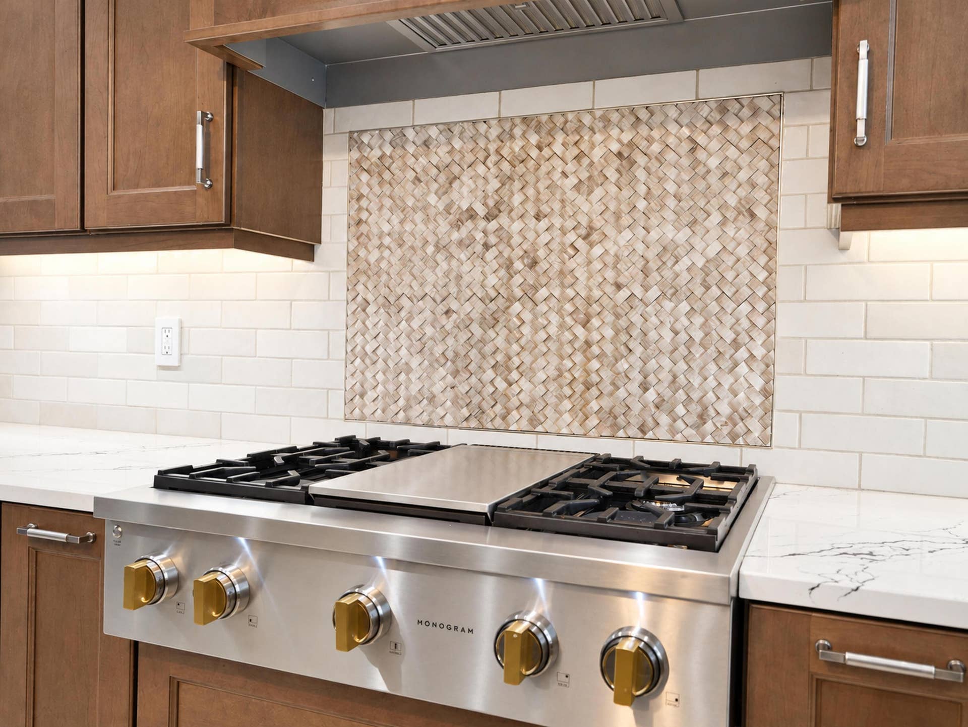 8601 Waterside Court, Parkland, FL 33076 Stainless steel gas range with integrated griddle, custom basket-weave tile backsplash, light-toned stone countertops, subway tile wall accents, and stained wood cabinetry with metal hardware