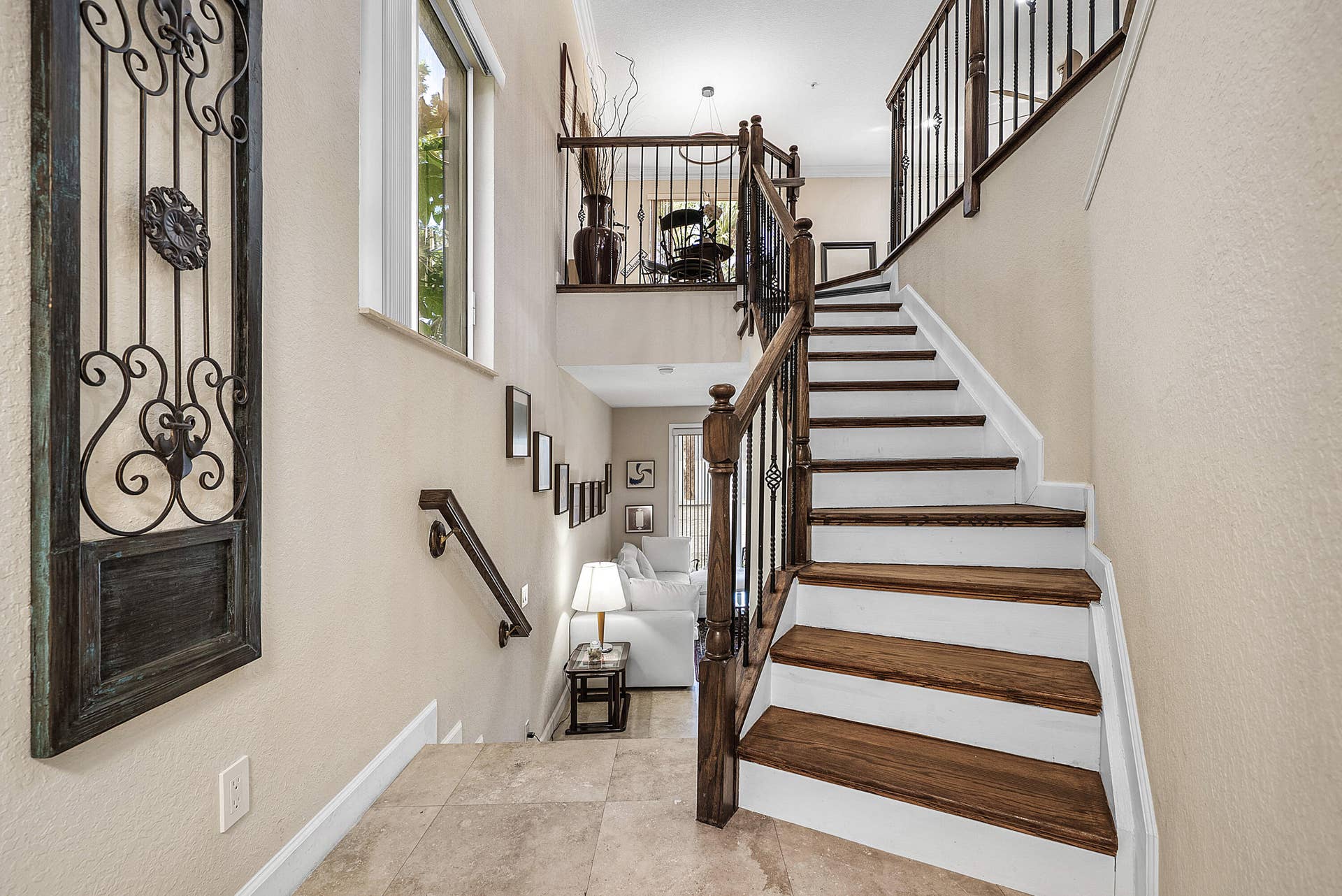 Multi-level interior featuring wood-finish stair treads and wrought iron staircase