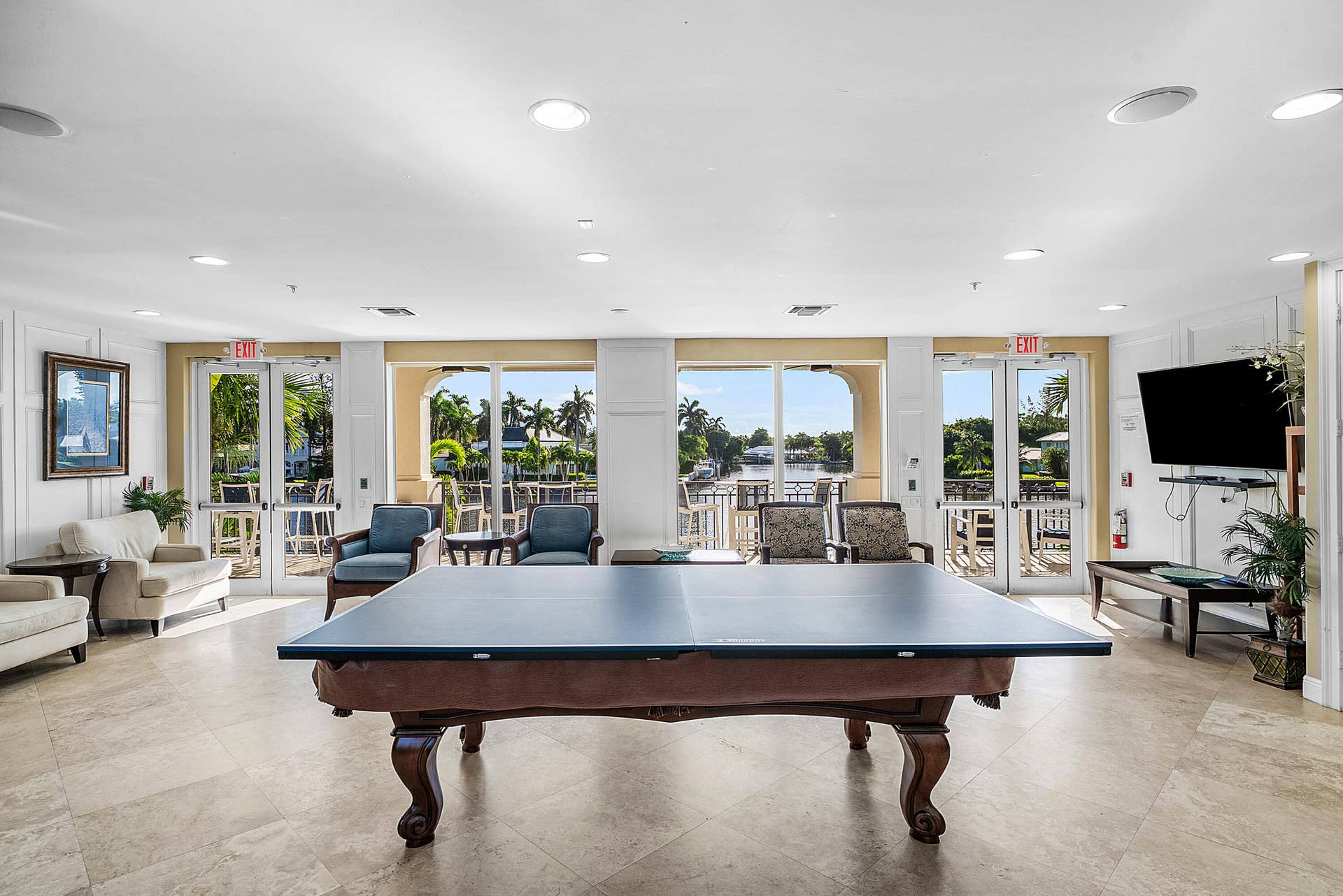 Expansive recreational space featuring a billiards table, recessed lighting, and direct access to an outdoor patio with water frontage