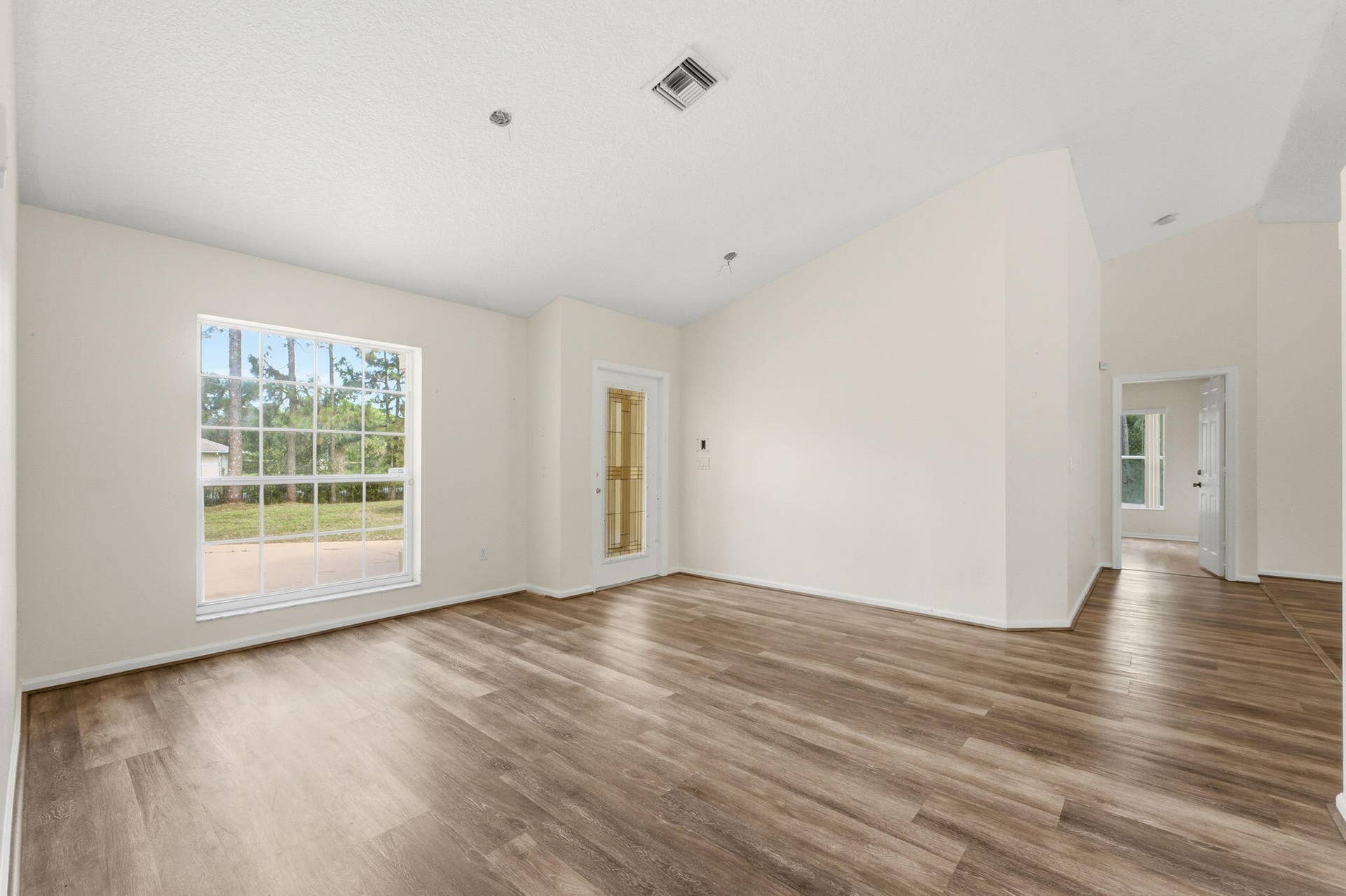 Vaulted ceilings, wood-finish flooring, and a single-hung window with a muntin grid