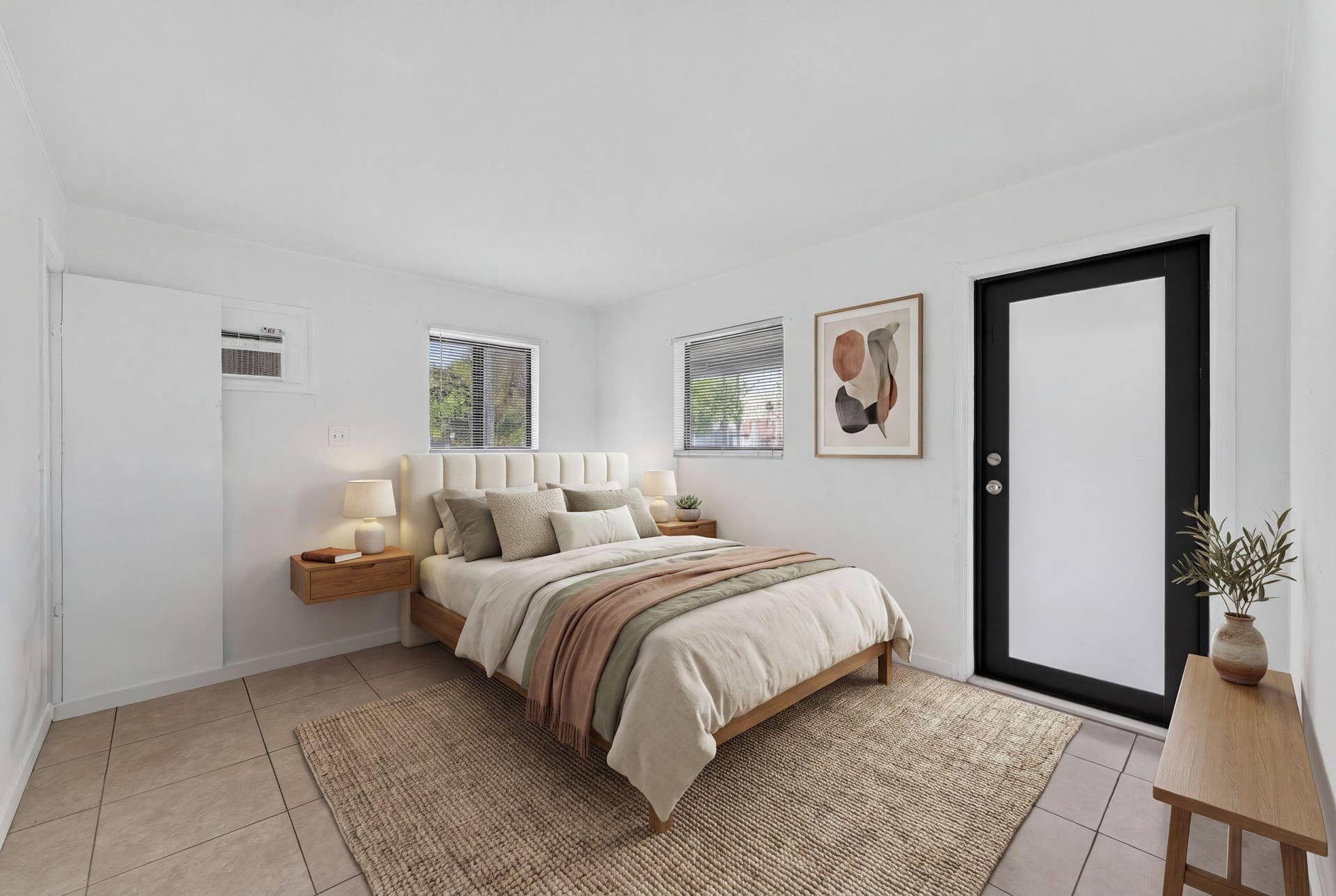 1224 NE 5TH Avenue, Fort Lauderdale, FL 33304 Neutral-toned interior space featuring light-colored tile flooring, multiple windows, and a black-framed exterior door with glass inlay