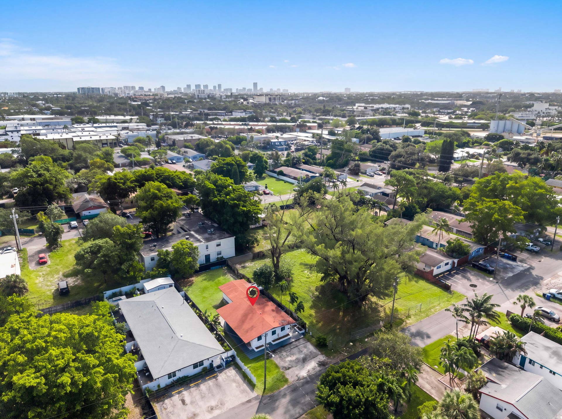 1224 NE 5TH Avenue, Fort Lauderdale, FL 33304 Aerial perspective of a property featuring a pitched red roof, private driveway, and mature landscaping within a suburban setting