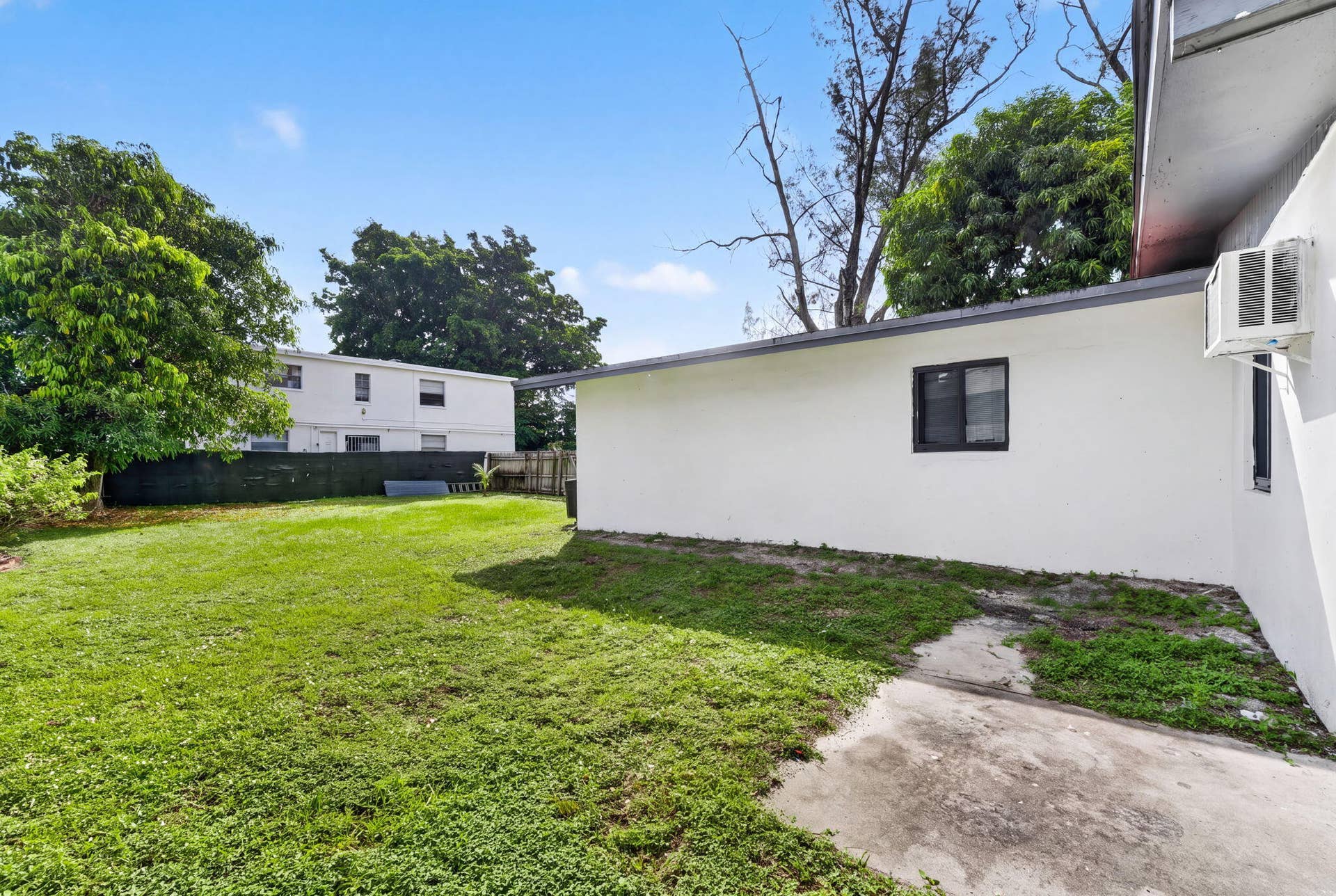 1224 NE 5TH Avenue, Fort Lauderdale, FL 33304 Backyard featuring a grass lawn, perimeter fencing, and concrete patio area