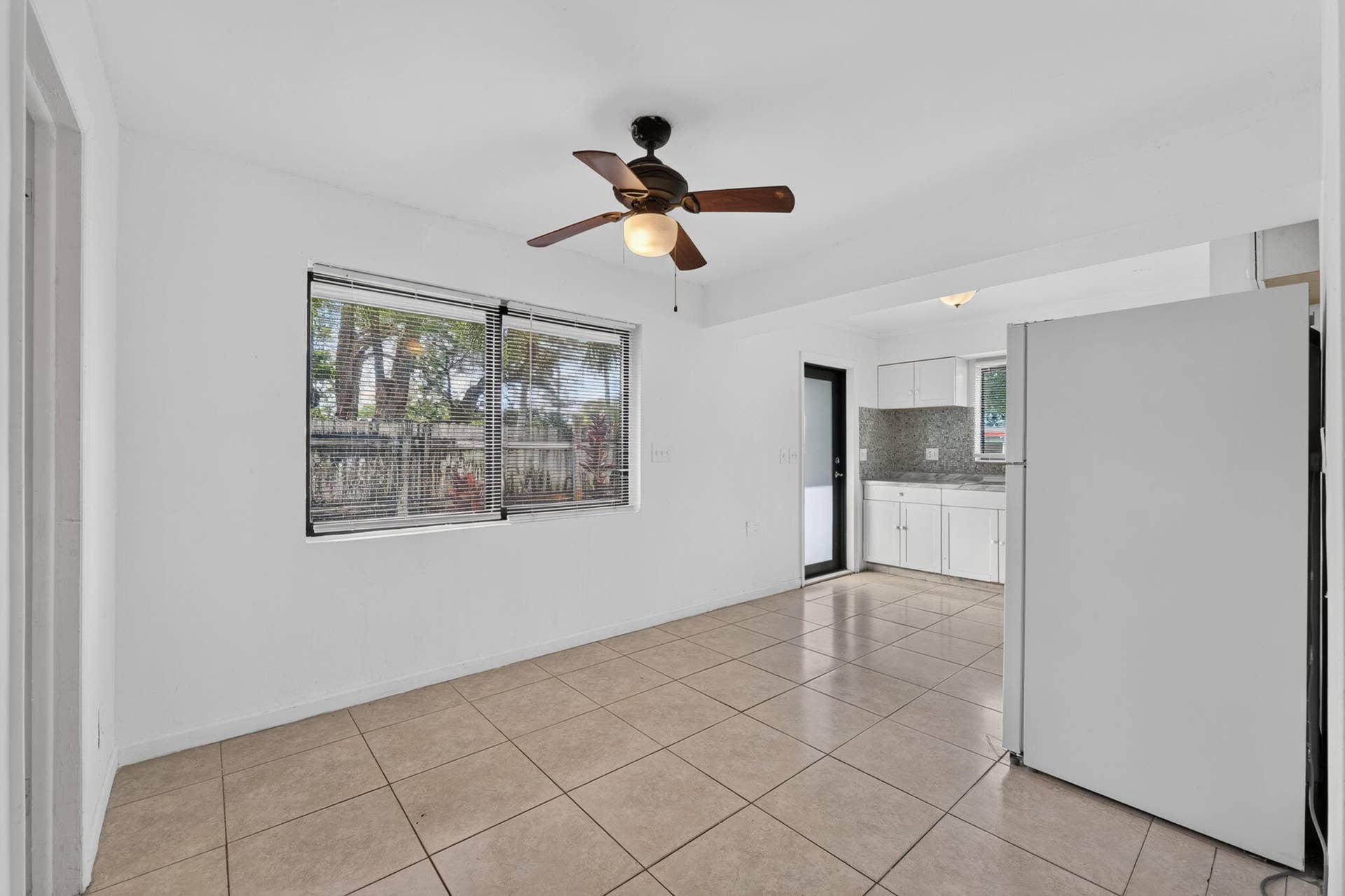 1224 NE 5TH Avenue, Fort Lauderdale, FL 33304 Neutral tile flooring, ceiling fan with integrated lighting, dual-pane windows, and white cabinetry