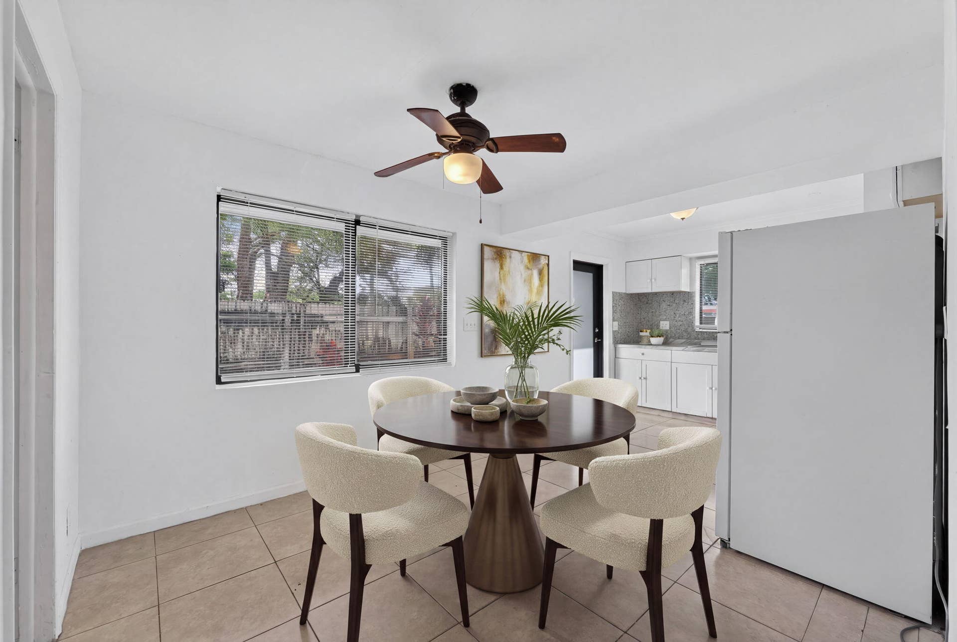 1224 NE 5TH Avenue, Fort Lauderdale, FL 33304 Tile flooring, dual-pane window, ceiling fan with light fixture, and white cabinetry