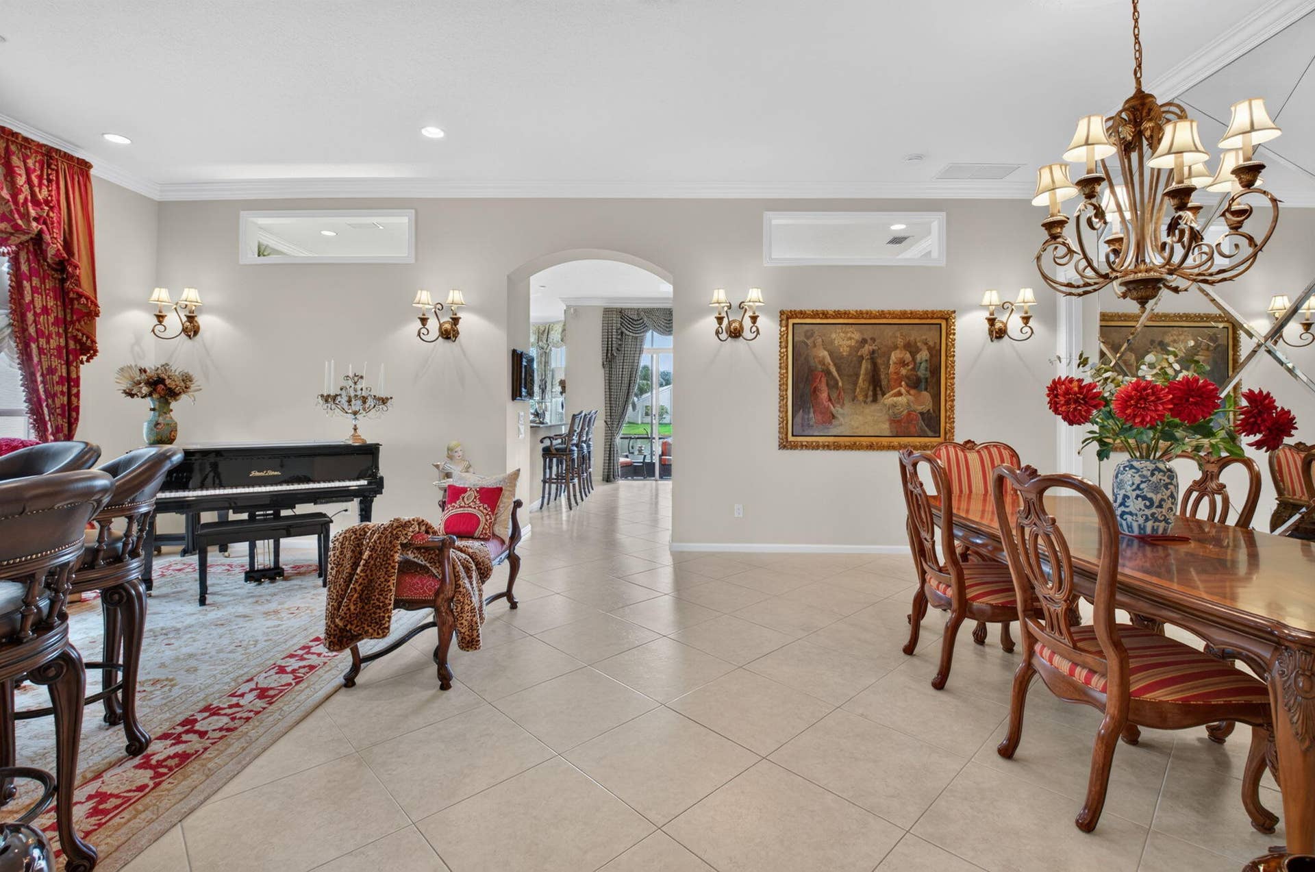 6874 Venidita Beach Drive, Delray Beach, FL 33446 Large-format tile flooring, arched entry, transom windows, multi-arm chandelier, and mirrored wall feature