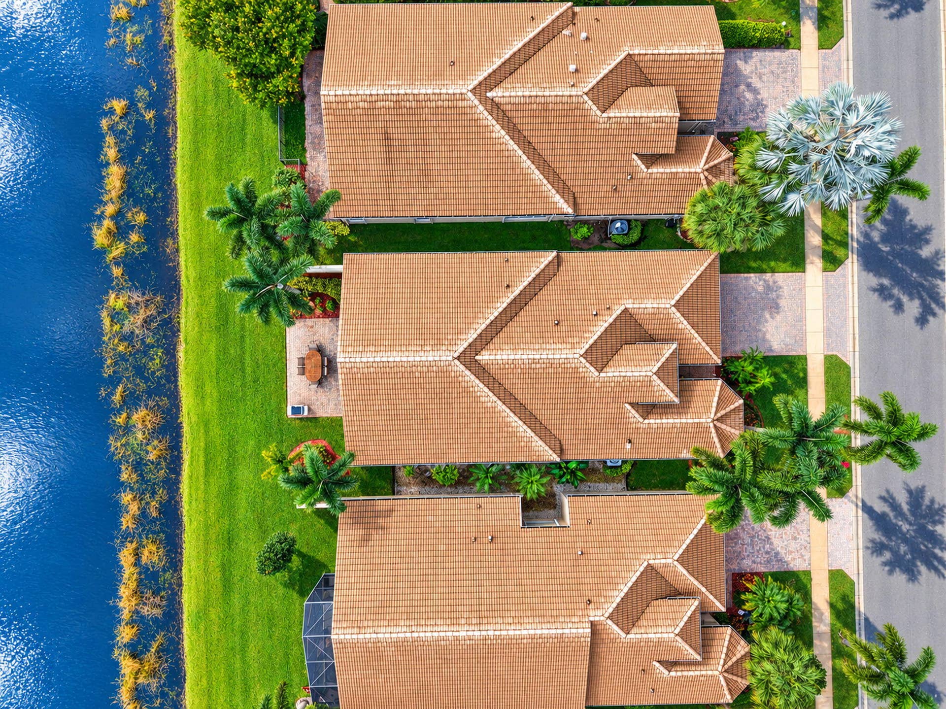 6874 Venidita Beach Drive, Delray Beach, FL 33446 Waterfront property featuring tile roofing, brick-paved driveways, and mature landscaping