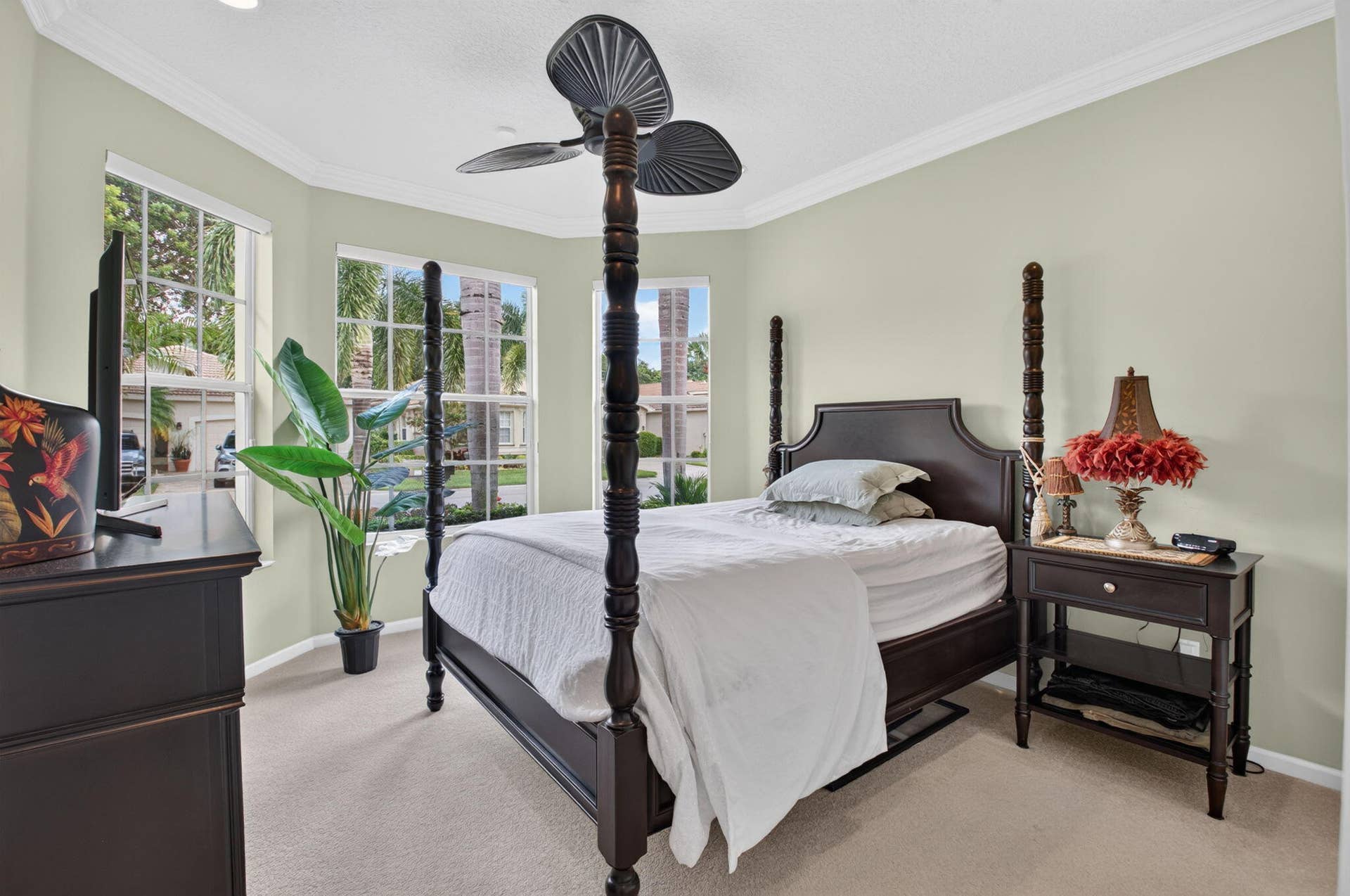 6874 Venidita Beach Drive, Delray Beach, FL 33446 Bay window featuring multi-pane windows, crown molding, neutral carpeting, and a multi-blade ceiling fan