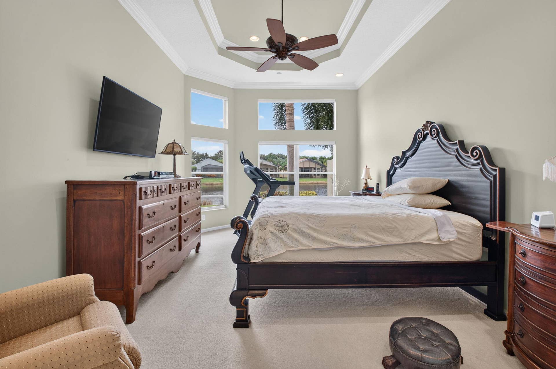 6874 Venidita Beach Drive, Delray Beach, FL 33446 Tray ceiling with crown molding, ceiling fan, carpeted flooring, and a bay window featuring multi-pane glass