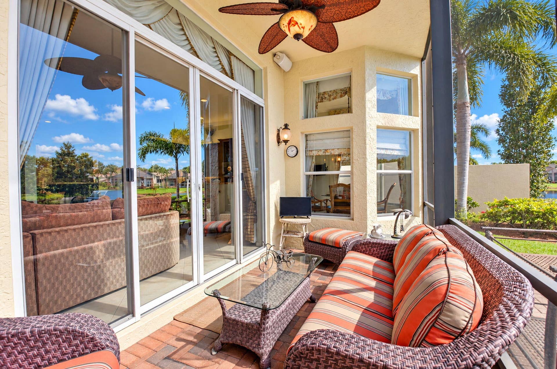 6874 Venidita Beach Drive, Delray Beach, FL 33446 Screened-in lanai featuring paver flooring, a ceiling fan with leaf-shaped blades, and expansive sliding glass doors