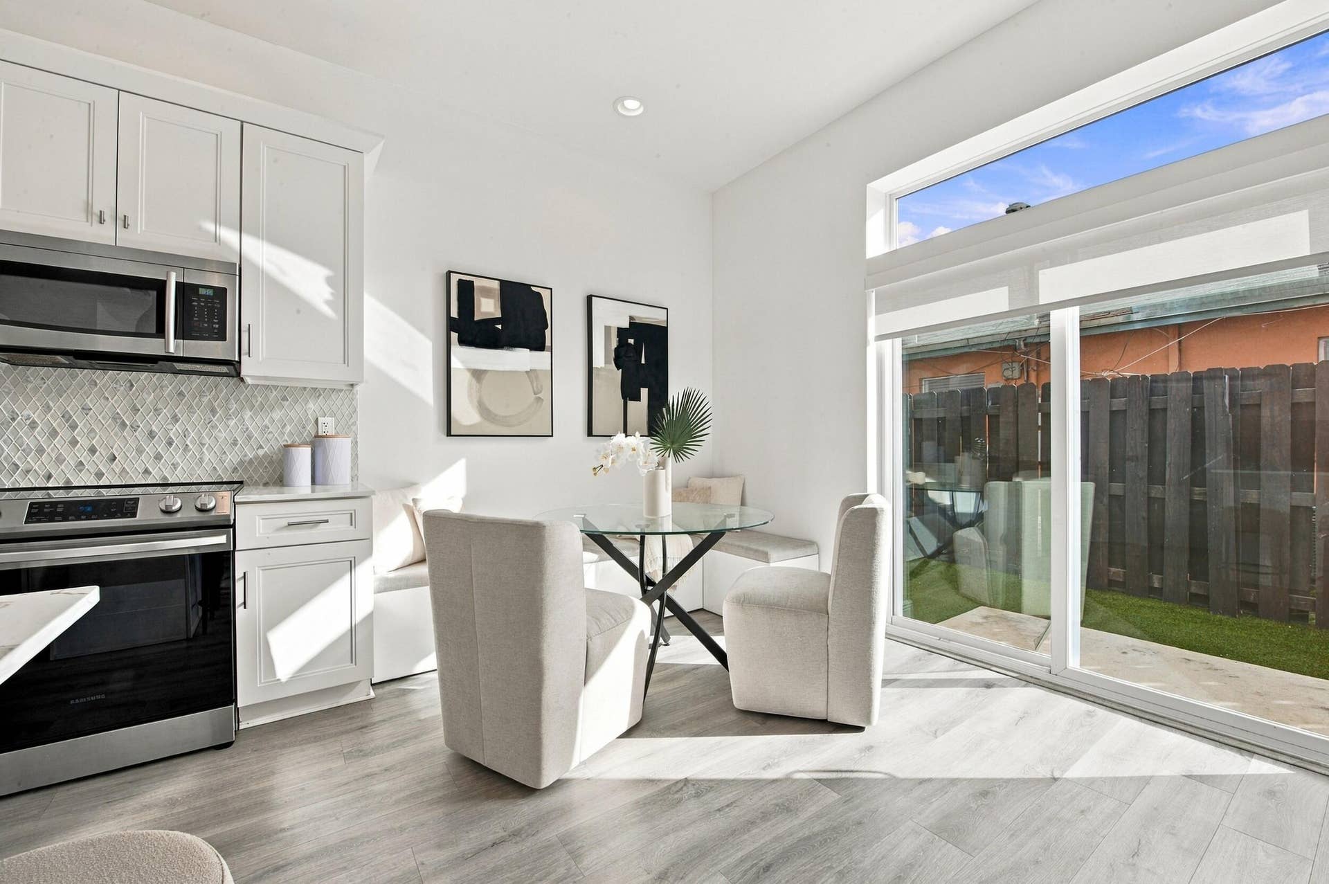 1066 NE 35TH Street, Oakland Park, FL 33334 Built-in bench seating, wood-finish flooring, sliding glass door with transom window, and wall-mounted shelving