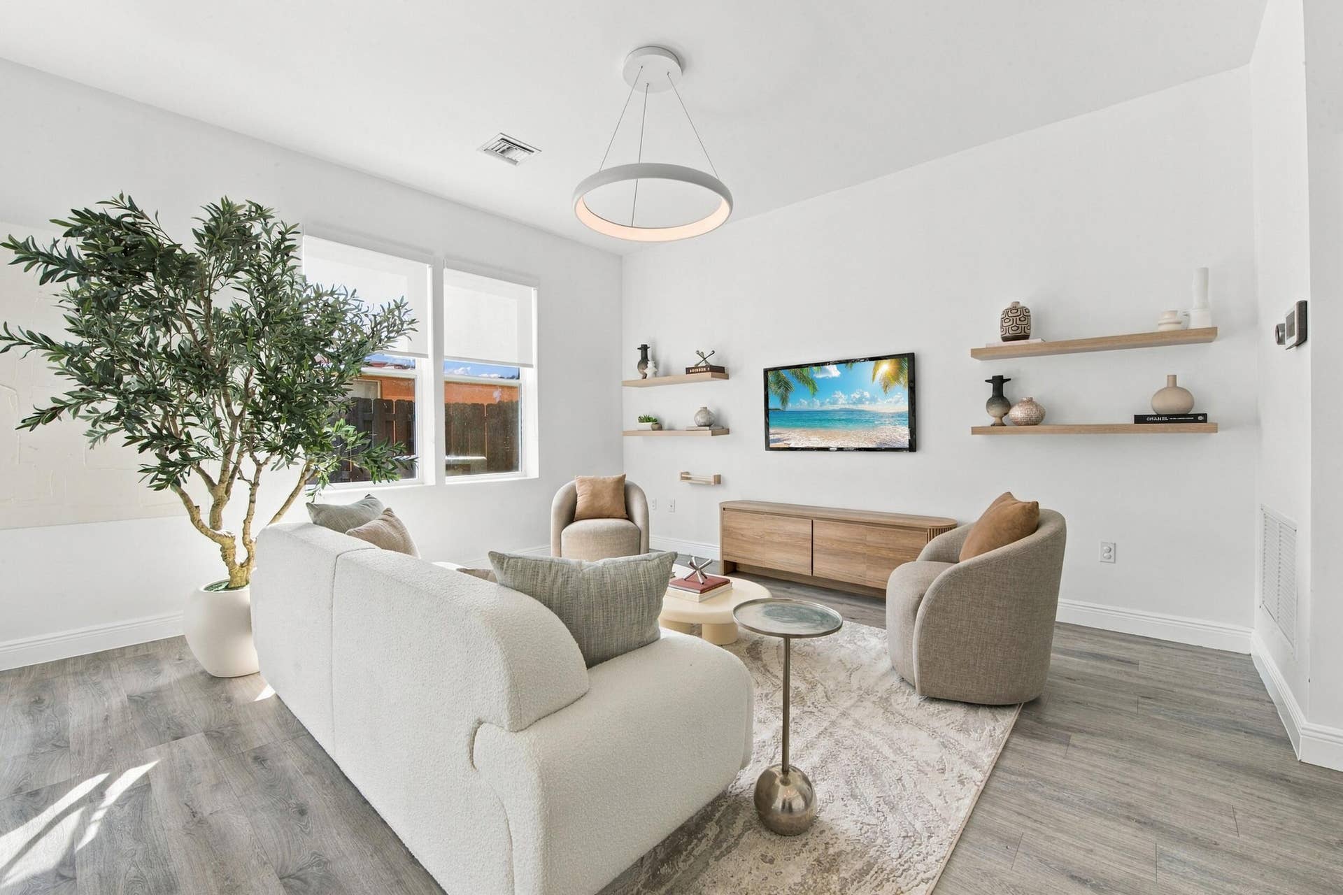 1066 NE 35TH Street, Oakland Park, FL 33334 Living space featuring wood-finish flooring, recessed lighting, double-pane windows, and minimalist wall-mounted shelving
