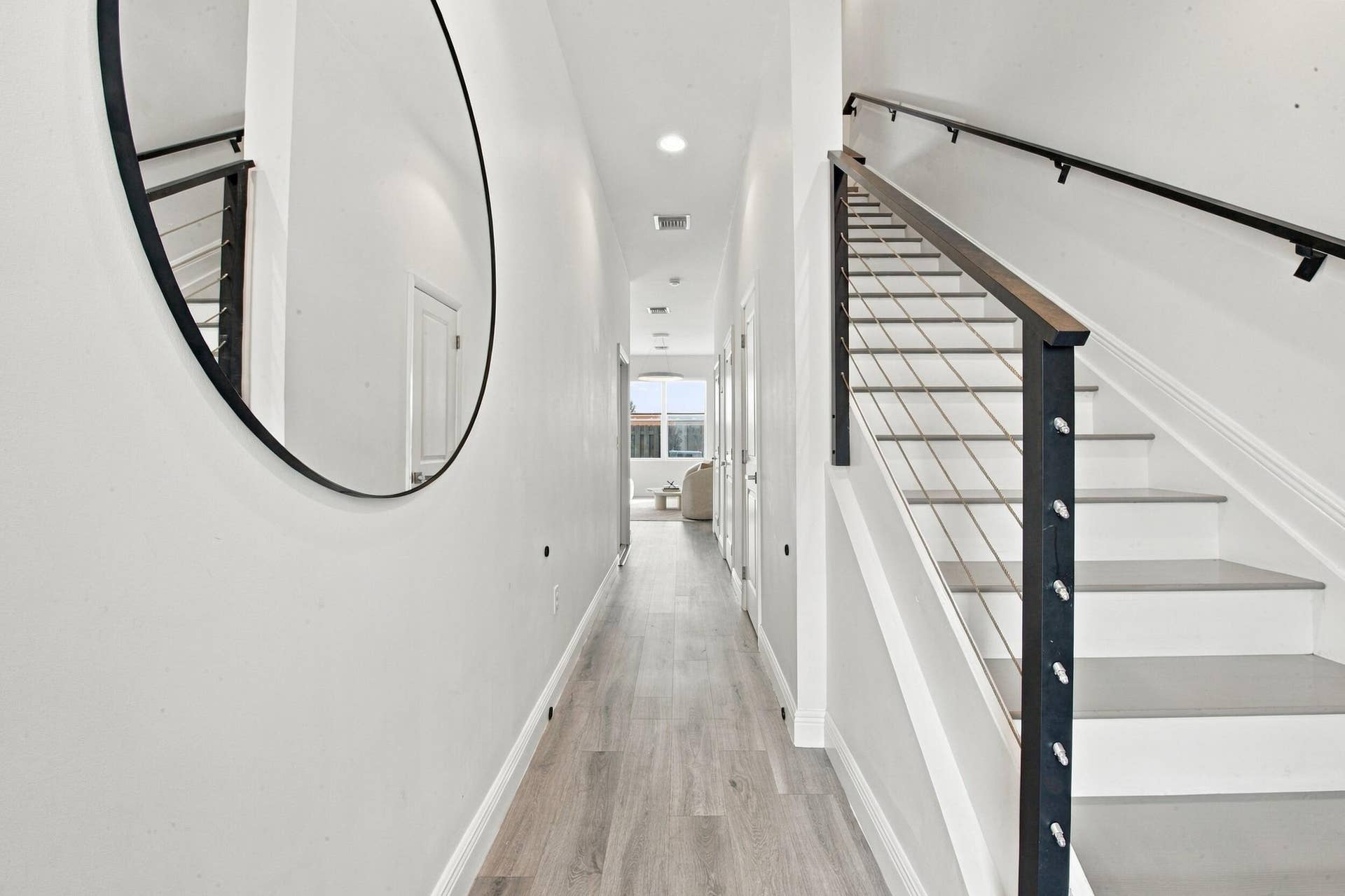 1066 NE 35TH Street, Oakland Park, FL 33334 Hallway featuring wood-finish flooring, recessed lighting, and a staircase with a matte black metal railing and horizontal cable balusters