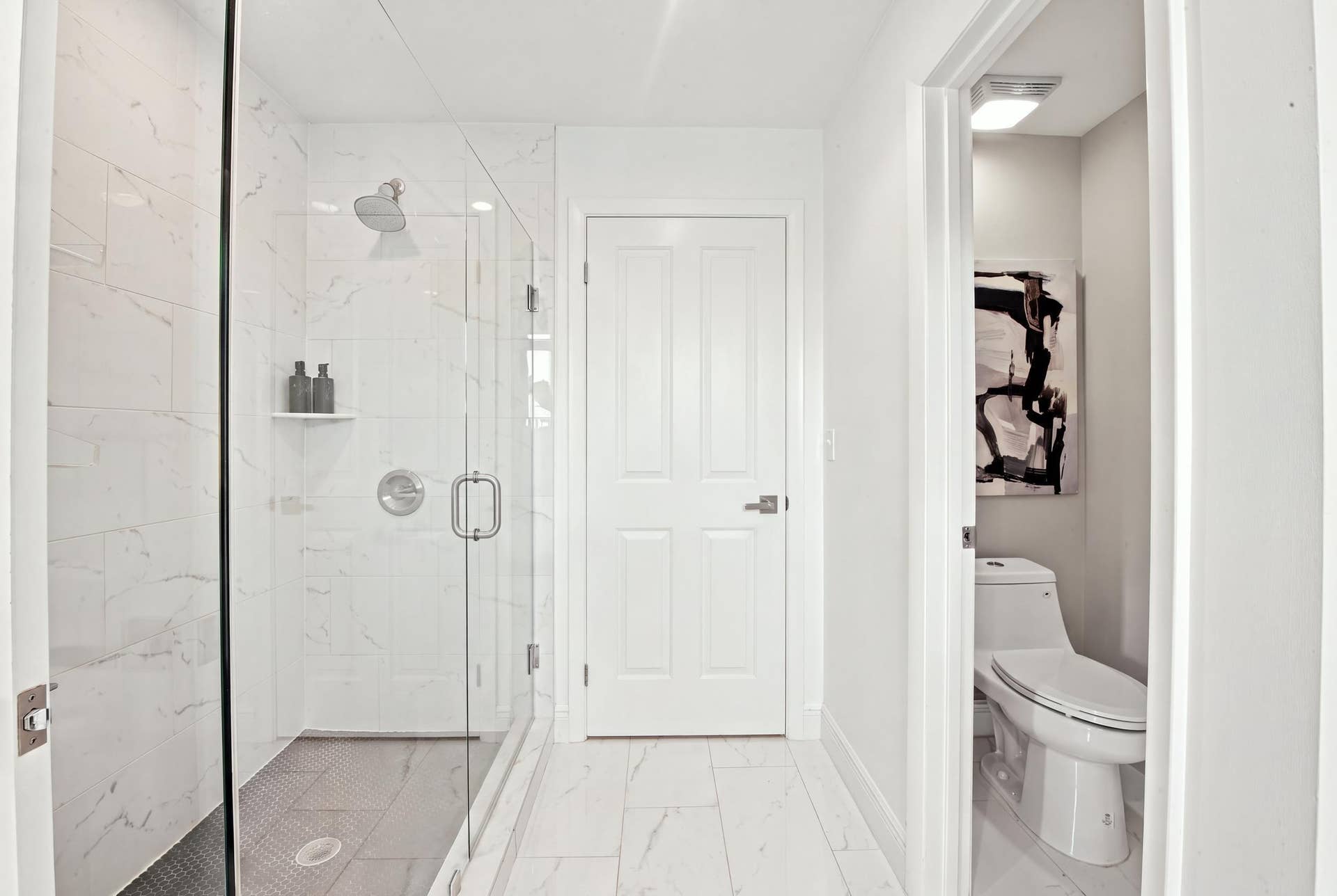 1066 NE 35TH Street, Oakland Park, FL 33334 Walk-in shower with floor-to-ceiling stone-pattern tile, frameless glass enclosure, built-in shelving, and fixed shower head